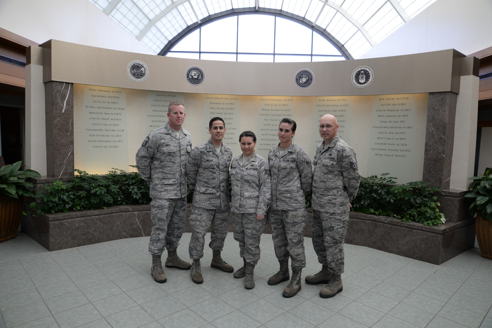 Leadership from the 934th Force Support Squadron, Minneapolis St. Paul Air Reserve Station, Minn., take time for a group photo with deployed 934th FSS members in front of the Air Force Mortuary Affairs Operations memorial wall during a unit morale visit to Dover Air Force Base, Del. From left to right, Senior Master Sgt. Roy Smith, 934th Sustainment Services flight superintendent, Maj. Jason Miller, 934th Sustainment Services flight commander, Tech. Sgt. Sandy Anderson, AFMAO command, control and communication technician, Senior Airman Lauren DePatto, AFMAO Fisher House for Families of the Fallen manager, and Tech. Sgt. Richy Krueger, an AFMAO  dress and restoration specialist. (U.S. Air Force photo/ Staff Sgt. Lucas Morrow)