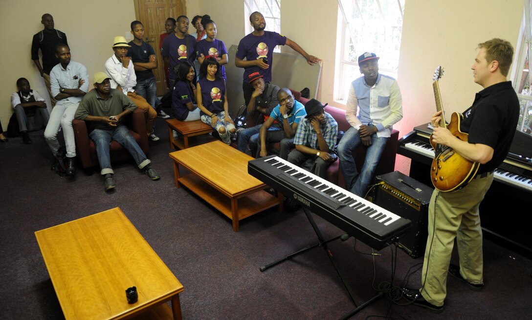 U.S. Air Forces in Europe’s Wings of Dixie jazz band guitarist Staff Sgt. Joseph Gacioch teaches and explains guitar techniques to South African music students prior to a free, live concert at the Music Academy of Gauteng in Benoni, South Africa, Sept 18, 2014. Gacioch and the five other members of Wings of Dixie played a two-hour musical set featuring the musical styles of jazz, funk and blues. (U.S. Air Force photo/Tech. Sgt. Austin M. May/Released)