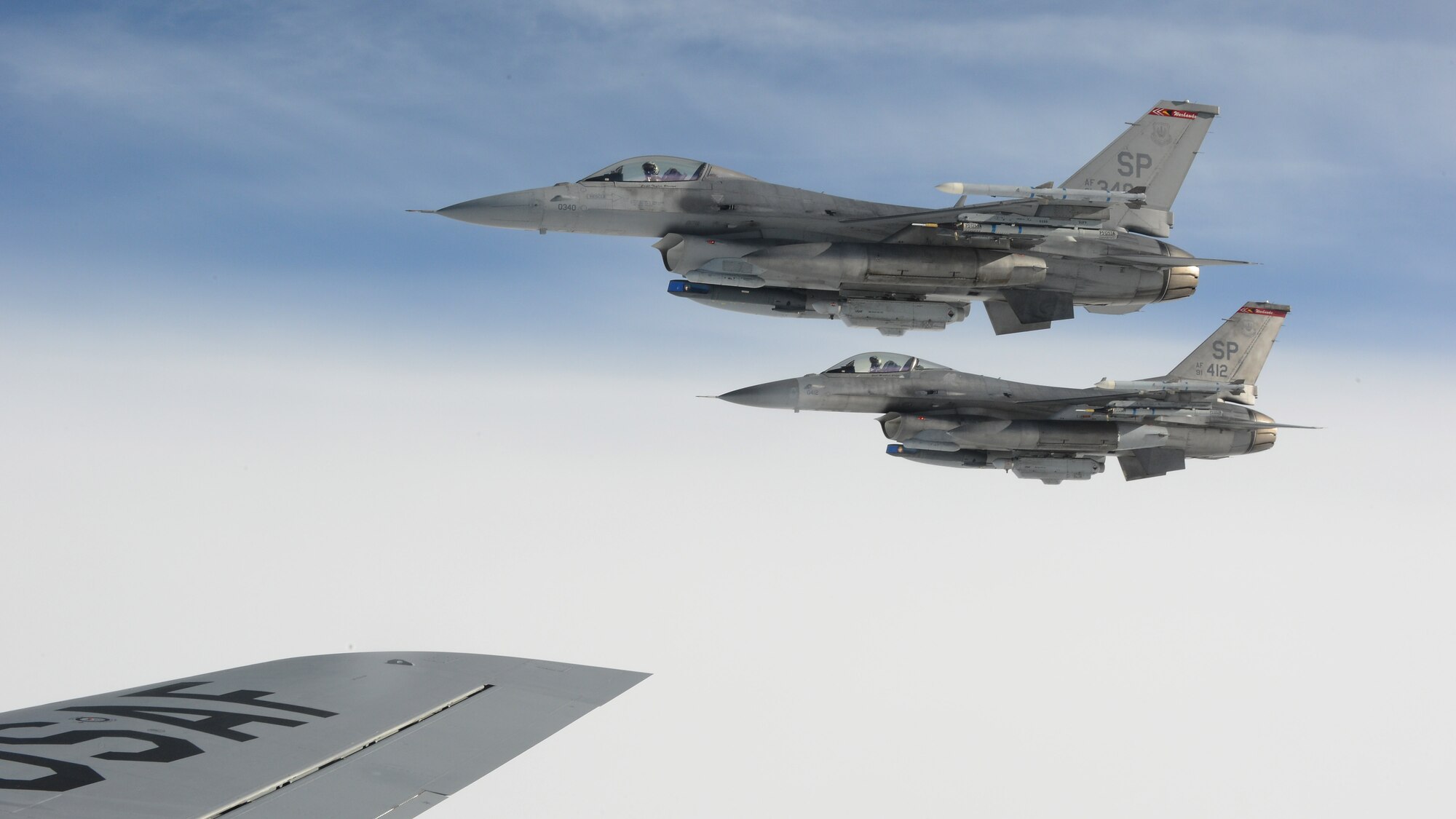 Two U.S. Air Force F-16 Fighting Falcon fighter aircraft from the 52nd Fighter Wing fly in formation beside the wing of a U.S. Air Force KC-135 Stratotanker during an aerial refueling mission at Spangdahlem Air Base, Germany, Sept 18, 2014. Six pilots from the 52nd FW participated in the refueling mission.  (U.S. Air Force photo by Airman 1st Class Luke J. Kitterman/Released)