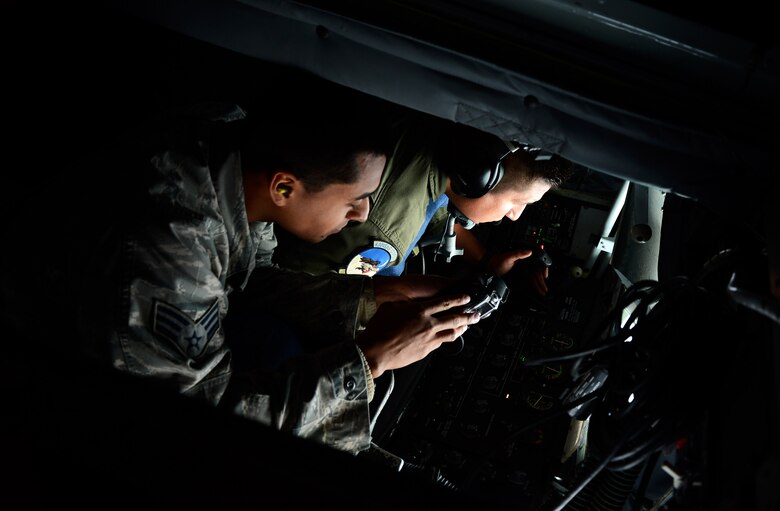 U.S. Air Force Senior Airman Francisco J. Bautista, a 480th Air Maintenance Squadron electrician, watches as U.S. Air Force Tech. Sgt. Ben Tressler, an in-flight refueling specialist from the 117th Air Refueling Squadron, operates the boom of a KC-135 Stratotanker to refuel a U.S. Air Force F-16 Fighting Falcon fighter aircraft during a refueling mission at Spangdahlem Air Base, Germany, Sept. 18, 2014. Bautista, along with other Airmen from Spangdahlem, went on the flight to see first-hand how a refueling mission operates in the air. (U.S. Air Force photo by Airman 1st Class Luke J. Kitterman/Released)