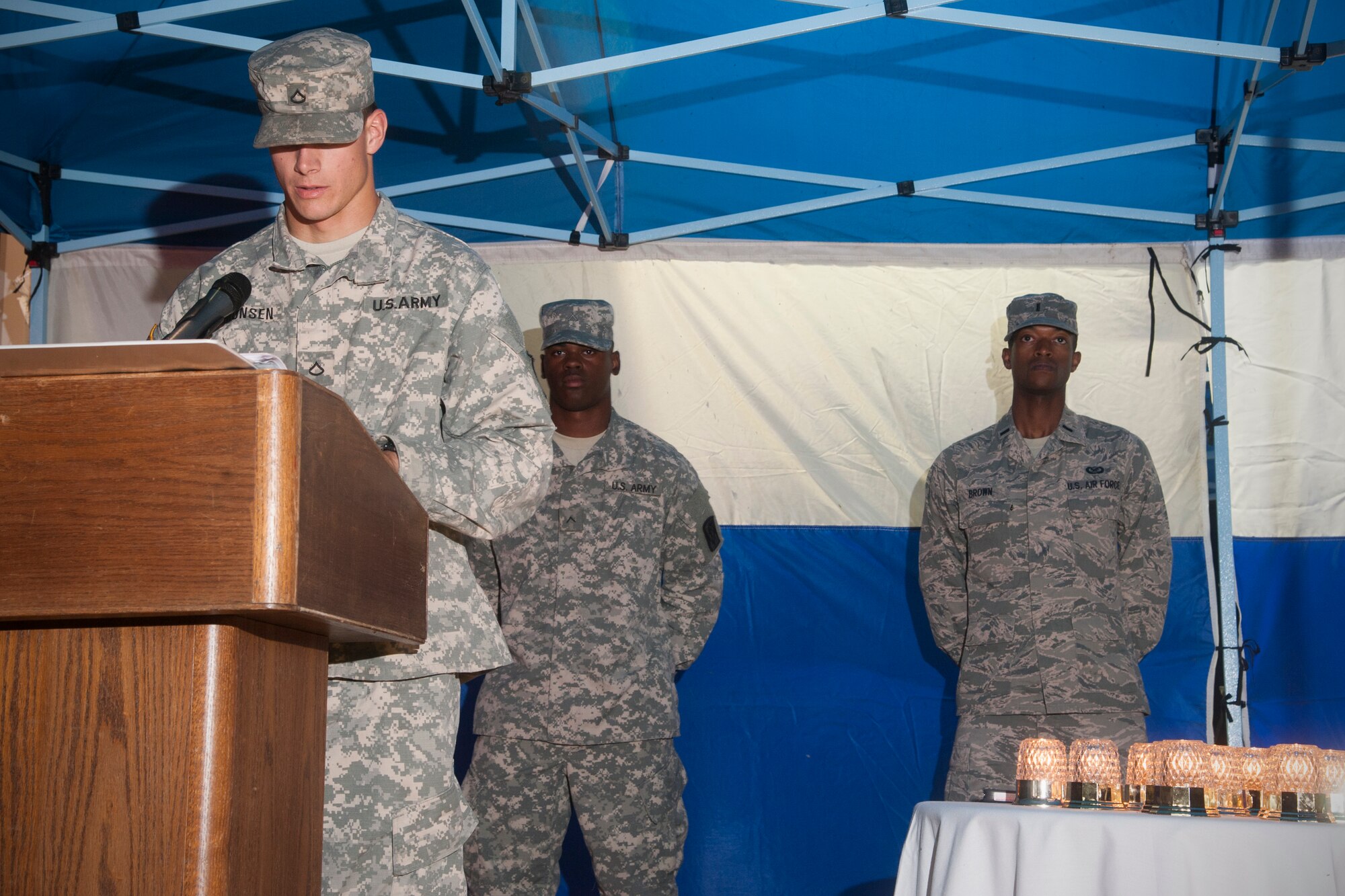 U.S. Soldiers with the Alpha Battery 2-1, 35th air Defense Artillery Brigade take turns with U.S. Airmen of the 8th Fighter Wing in the late evening to read names at the vigil in honor of POW/MIA Recognition Day at Kunsan Air Base, Republic of Korea, Sept. 18, 2014. Airmen and Soldiers at Kunsan AB commemorated U.S. prisoners of war and those missing in action with a 24-hour run and vigil. (U.S. Air Force photo by Senior Airman Taylor Curry/Released)