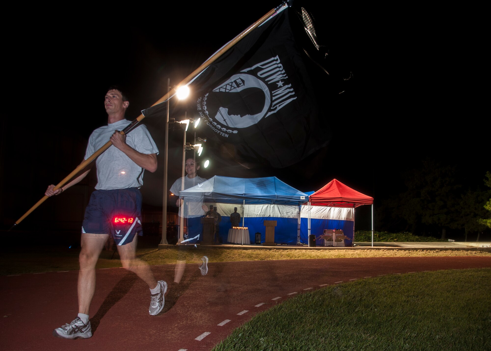 Tech. Sgt. Kurtis Douge, 8th Operations Support Squadron survival, evasion, resistance and escape specialist, carries the POW/MIA flag during the 24-hour run and vigil to honor POW/MIA Recognition Day at Kunsan Air Base, Republic of Korea, Sept. 18, 2014. The Wolf Pack community volunteered to take turns carrying the POW/MIA flag during the run and to read aloud names at the vigil non-stop for 24 hours. (U.S. Air Force photo by Senior Airman Taylor Curry/Released)
