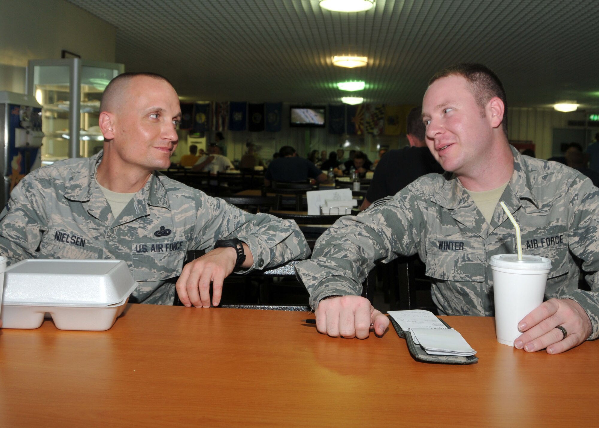 Air Force Master Sgt. James Nielsen listens to Air Force Senior Airman Erik Winter discuss goals for his mentorship program at the 380th Air Expeditionary Wing’s Oasis Dining Facility August 23. The two are participating in the wing’s “Adopt an Airman” program on base at an undisclosed location in Southwest Asia. (U.S. Air National Guard photo by Senior Master Sgt. Eric Peterson/Released)

