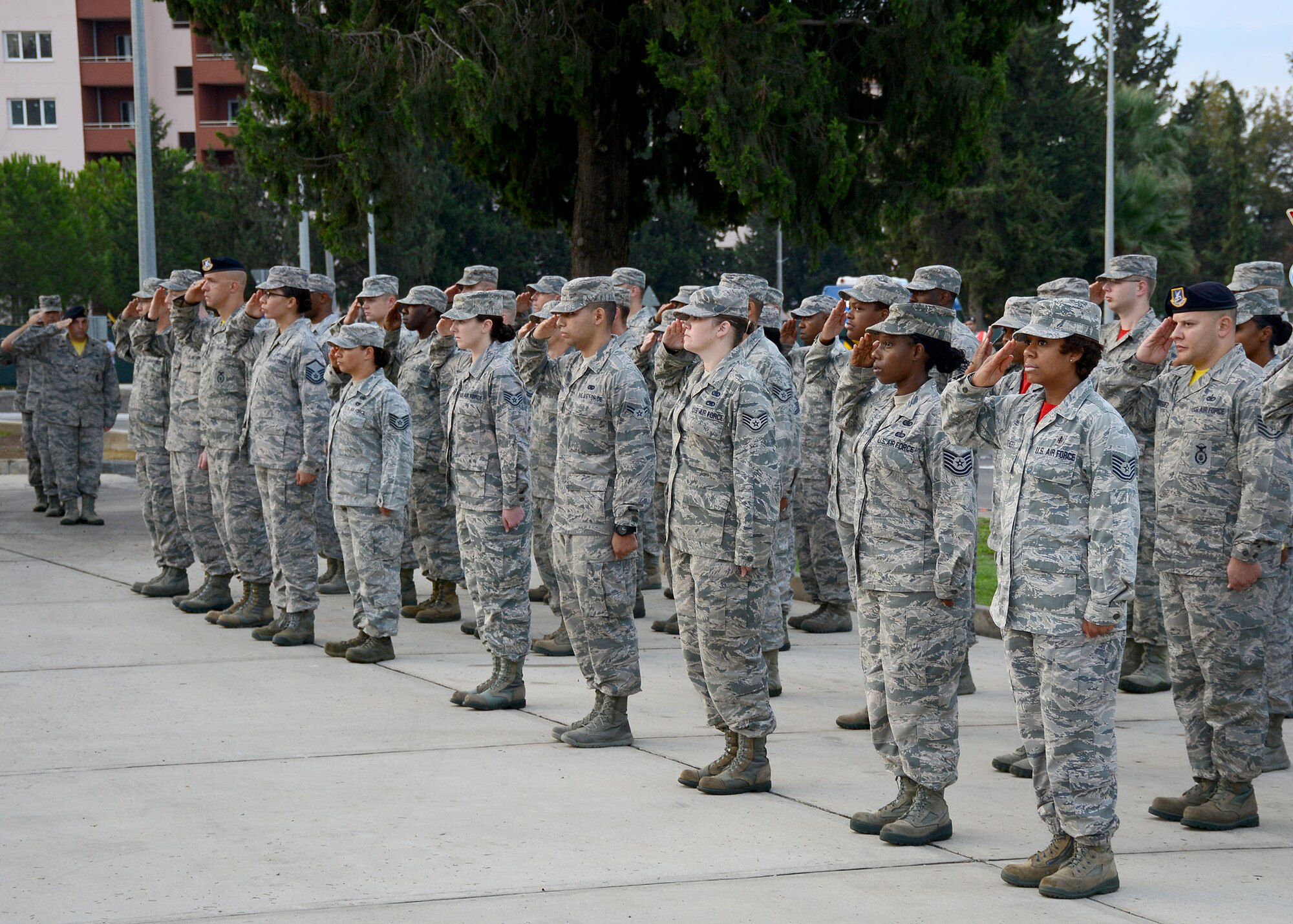 Members of the 39th Air Base Wing stand in formation saluting the American flag during a prisoner of war, missing in action remembrance ceremony Sept. 19, 2014, Incirlik Air Base, Turkey. Each year POW/MIA recognition day is observed the third Friday in September, which was established by the 101st Congress on Aug. 10, 1990. (U.S. Air Force photo by Staff Sgt. Veronica Pierce/Released)