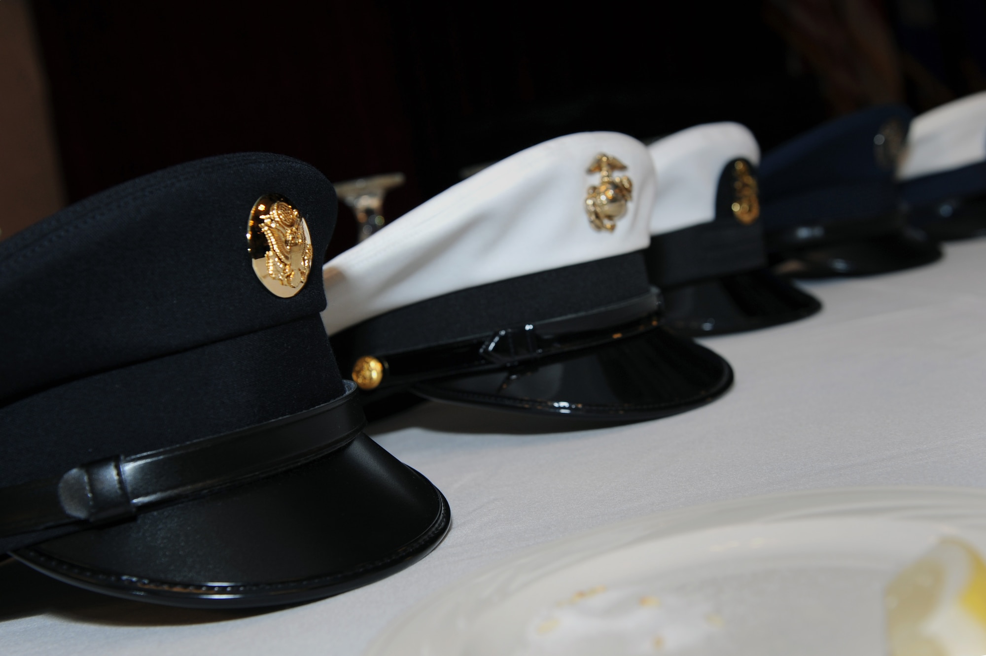Hats from each U.S. branch of service are set on the Prisoner of War and Missing in Action table in honor of National POW/MIA Recognition Day on Kadena Air Base, Japan, Sept. 19, 2014. The five hats represent POWs and MIA personnel from the U.S. Air Force, Army, Marine Corps, Navy and Coast Guard. (U.S. Air Force photo by Airman 1st Class Zade C. Vadnais/Released)