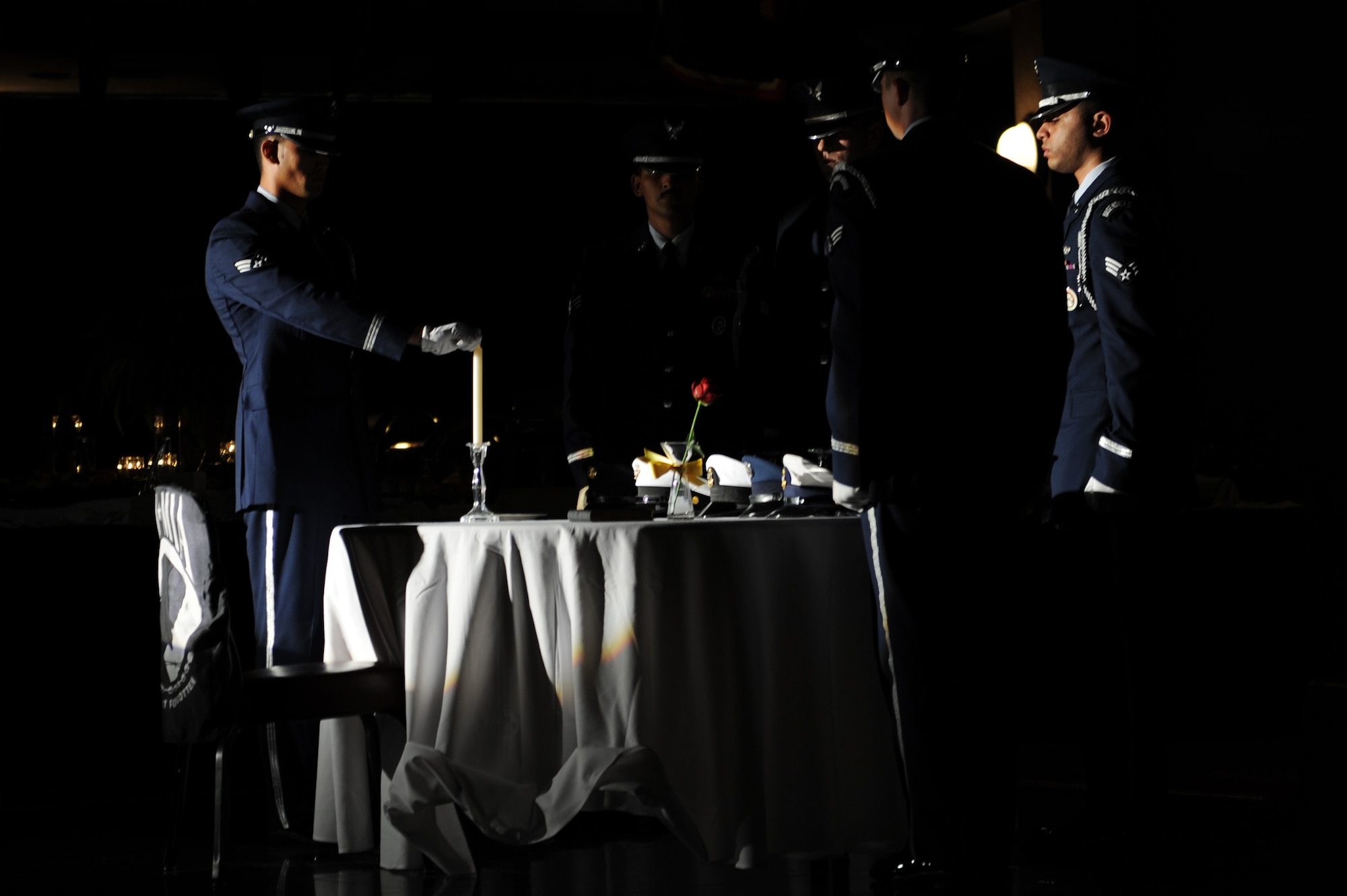 U.S. Air Force Honor Guardsmen prepare the Prisoner of War and Missing in Action table in observance of National POW/MIA Recognition Day on Kadena Air Base, Japan, Sept. 19, 2014. Instead of the traditional POW/MIA table set for one, this table was set for five to honor service members from the U.S. Air Force, Army, Marine Corps, Navy and Coast Guard. (U.S. Air Force photo by Airman 1st Class Zade C. Vadnais/Released)