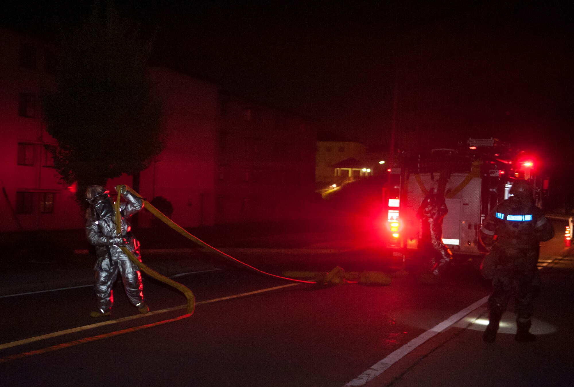 A fire fighter from the 51st Civil Engineer Squadron unravels a hose during a mass casualty exercise at Osan Air Base, Republic of Korea, Sept.17, 2014. This realistic exercise helps provide police, fire and ambulance agencies the opportunity to participate in a mass casualty exercise for emergency response training and evaluations. (U.S. Air Force photo by Senior Airman Matthew Lancaster)