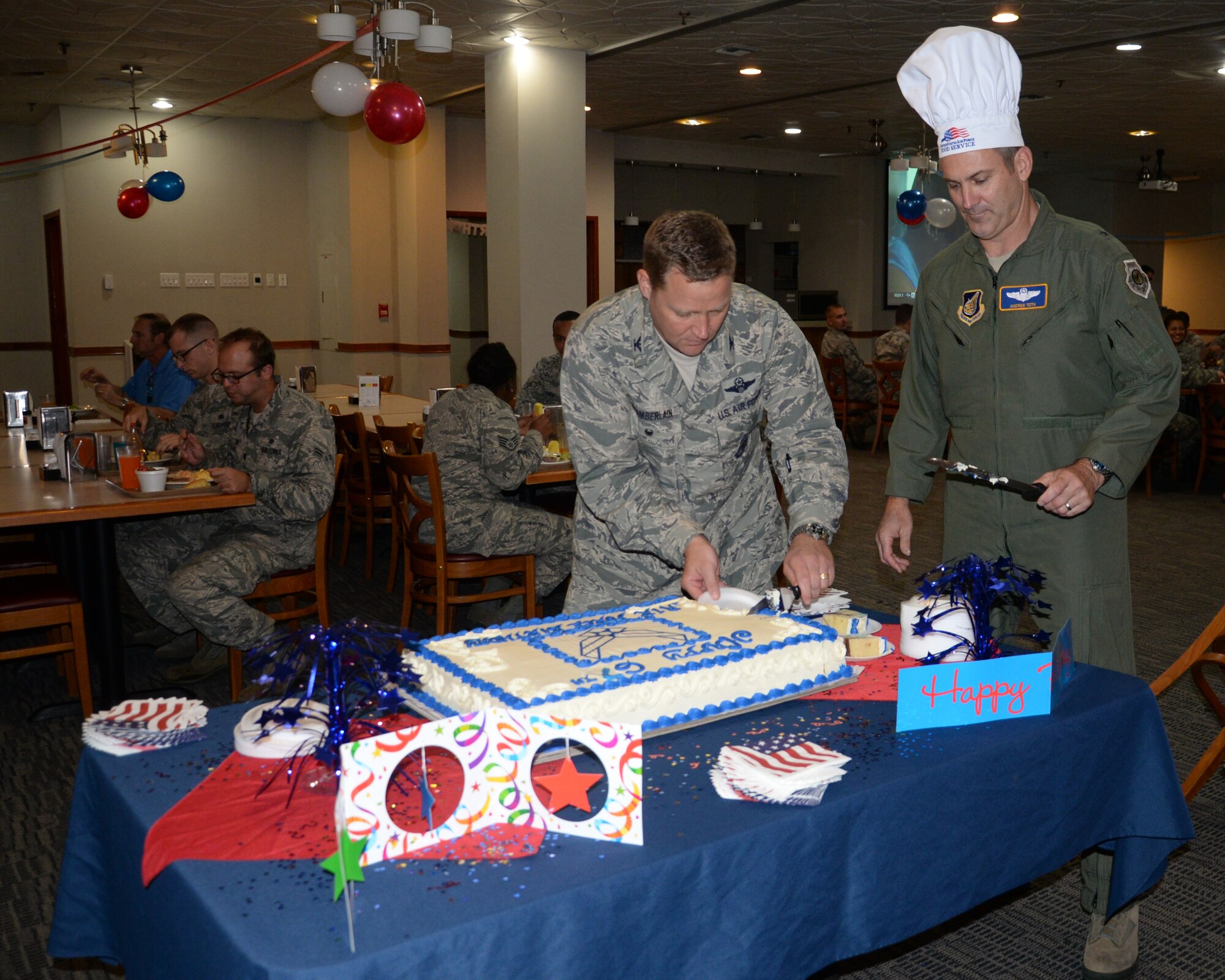 Brig. Gen. Andrew Toth, 36th Wing commander and Col. Tyrell Chamberlain, 36th Wg vice commander, prepare to serve cake to Airmen during the 67th Air Force birthday celebration at the Top of the Rock dining facility Sept. 18, 2014 on Andersen Air Force Base, Guam. The cake cutting celebrates the creation of the U.S. Air Force as an independent service in 1947, when the Air Force separated from the U.S. Army. (U.S. Air Force photo by Senior Airman Cierra Presentado/Released)