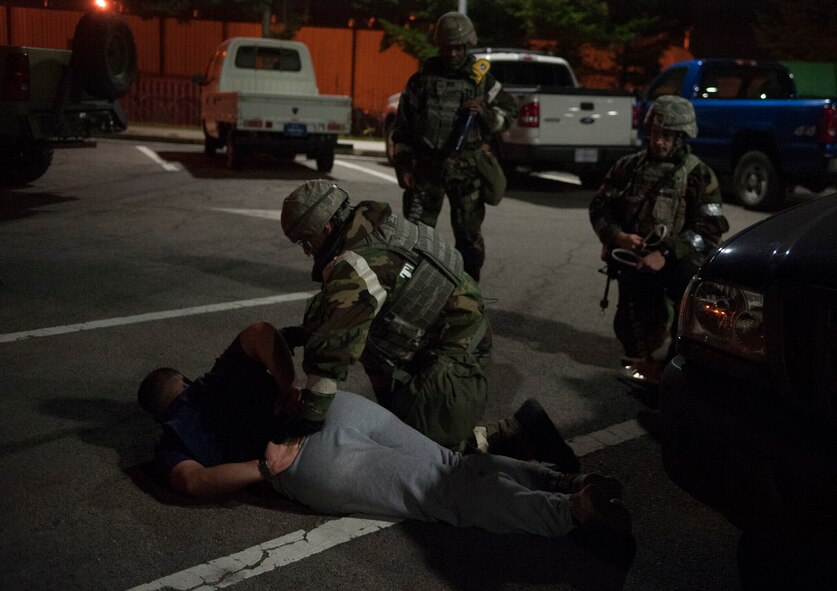 A 51st Security Forces member detains an opposition forces member during Operational Readiness Exercise Beverly Midnight 14-4 Sept. 17, 2014, at Osan Air Base, Republic of Korea. After the battle, SFS members check for casualties and surviviors. (U.S. Air Force photo by Senior Airman Matthew Lancaster)