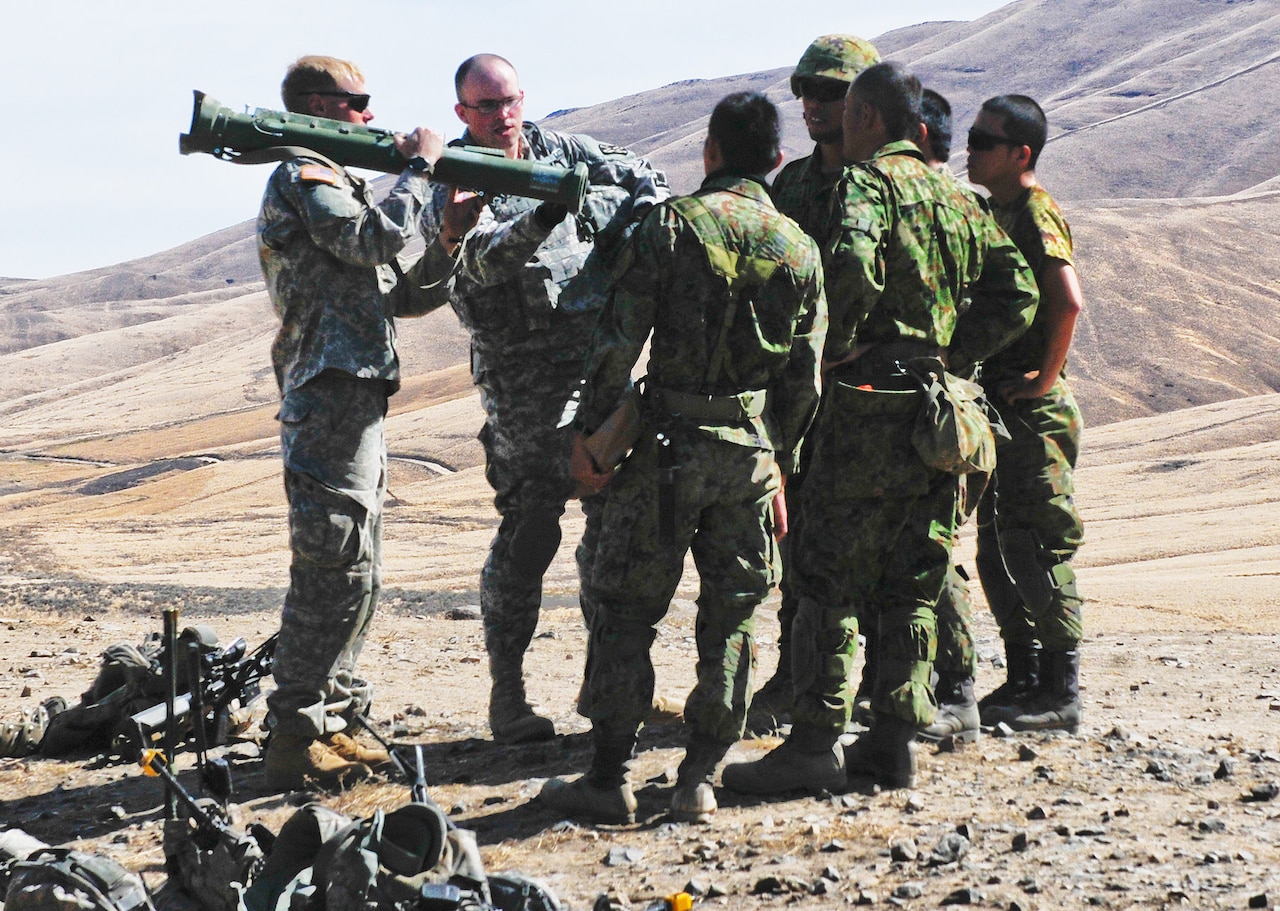 Army Spc. Joshua Williams translates between a U.S. soldier and Japanese troops during an impromptu lunch-break lesson on special artillery during Operation Rising Thunder 2014 at Yakima Training Center, Wash., Sept. 8, 2014. Williams, a linguist in the Washington National Guard, worked as an interpreter for U.S. and Japanese forces during the operation, which began Sept. 2 and runs to Sept. 24. U.S. Army photo by Sgt. Deja Borden