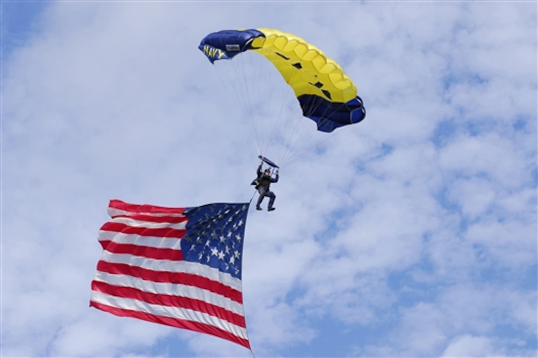 Navy Chief Brad Woodard carries the American flag as he prepares to land during the Star Spangled Spectacular in Baltimore, Md., Sept. 12, 2014. Woodard is a member of the Leap Frongs, the U.S. Navy's parachute demonstration team.