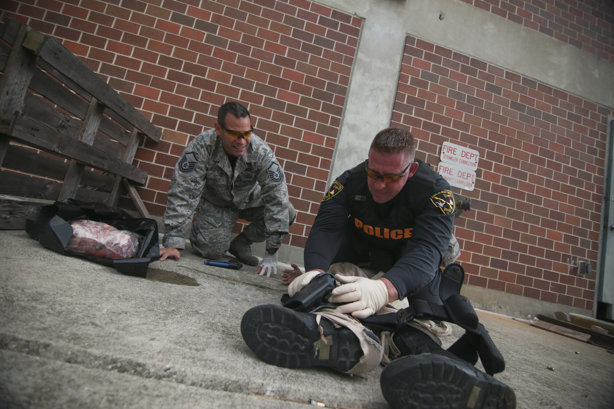 A picture of Long Beach Township Patrolman Matthew Compitello working on a simulated patient while being shadowed by U.S. Air Force Master Sgt. Jose Almeida.