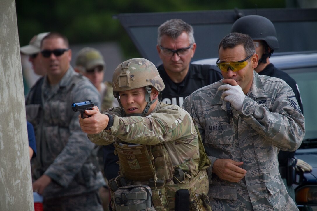 U.S. Air Force Staff Sgt. Sean Dixon fires sim rounds while Master Sgt. Jose Almeida blows a whistle as a distraction during Tactical Combat Casualty Care training at the Anthony "Tony" Canale Training Center in Egg Harbor Township, N.J., Sept. 19, 2014. The course, which was taught by Almeida, included students from the 177th Security Forces Squadron, the 227th Air Support Operations Squadron and numerous police officers from southern New Jersey. Dixon is a tactical air control party specialist from the 227th Air Support Operations Squadron. (U.S. Air National Guard photo by Tech. Sgt. Matt Hecht/Released)