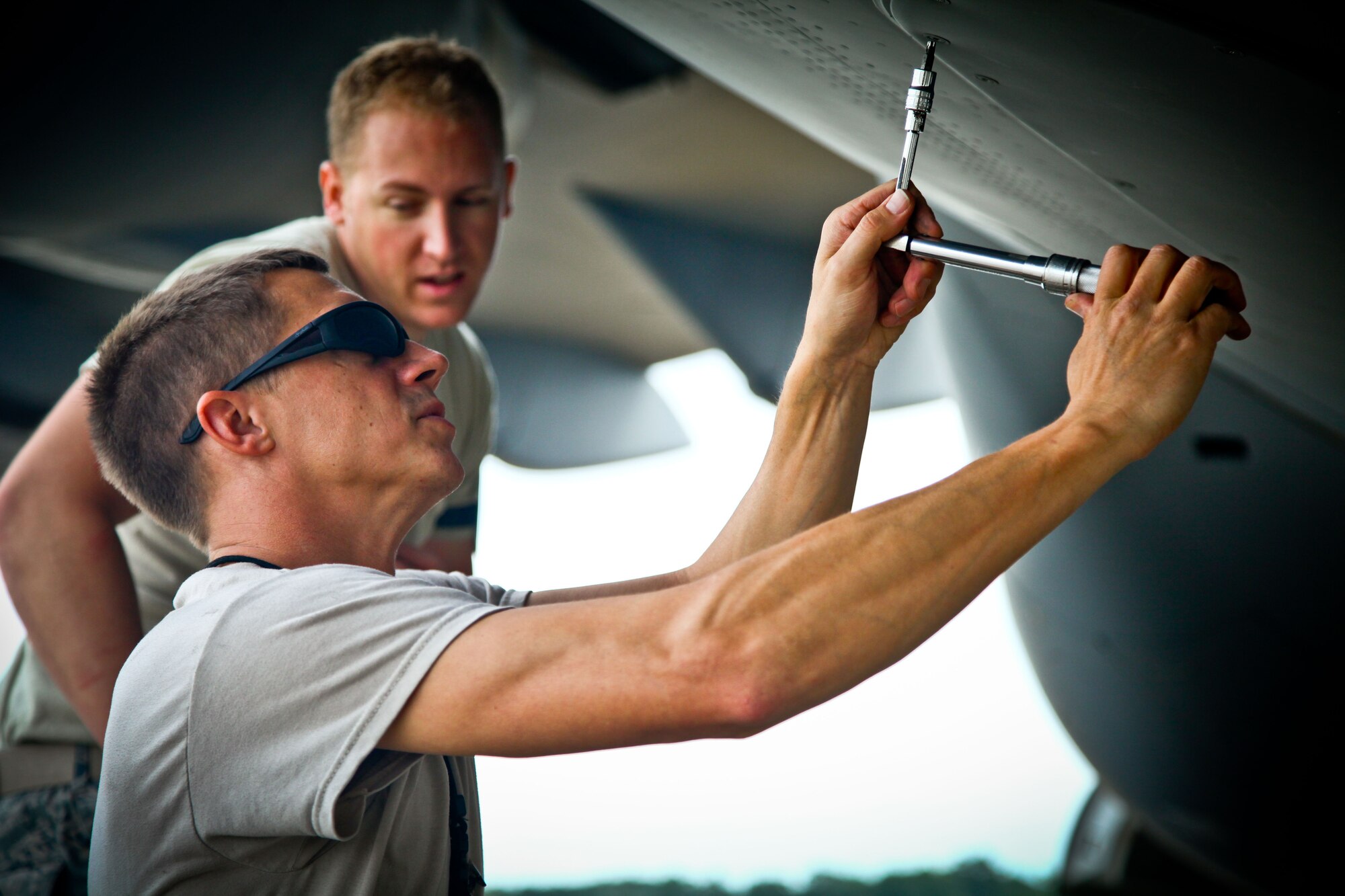 Tech. Sgt. Shawn Summers (foreground), a 315th Maintenance Group member and C-17 Globemaster III crew chief here at Joint Base Charleston, S.C., screws in a cover plate on the body of a C-17 yesterday on the aircraft ramp here at Joint Base Charleston, S.C. The 315th MXG provided operational flight line coverage yesterday while the 437th Maintenance Group took part in the active duty’s wingman day activities.  (U.S. Air Force photo by Staff Sgt. Rashard Coaxum)
