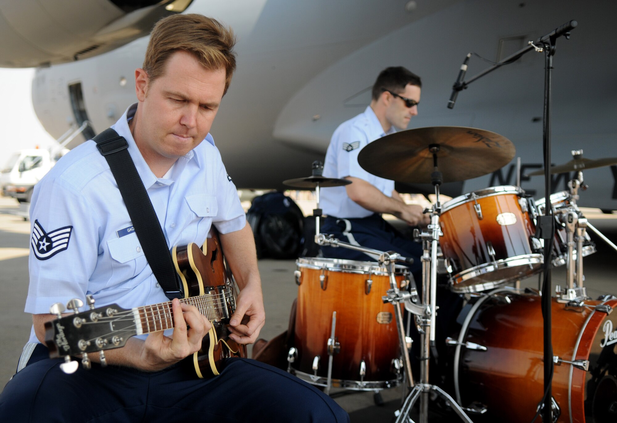 Staff Sgt. Joe Gacioch, guitarist, and the United States Air Forces in Europe jazz band, Wings of Dixie, perform beneath the wing of a New York Air National Guard C-17 Globemaster III at Africa's largest air show Sept. 20, 2014. A total force team of U.S. Air Force Airmen and U.S. Army Soldiers attended the Africa Aerospace & Defence Expo 2014 at Waterkloof Air Force Base, South Africa, to showcase the United States' commitment to its partnership with South Africa. (U.S. Air Force photo by Tech. Sgt. Austin M. May/Released)