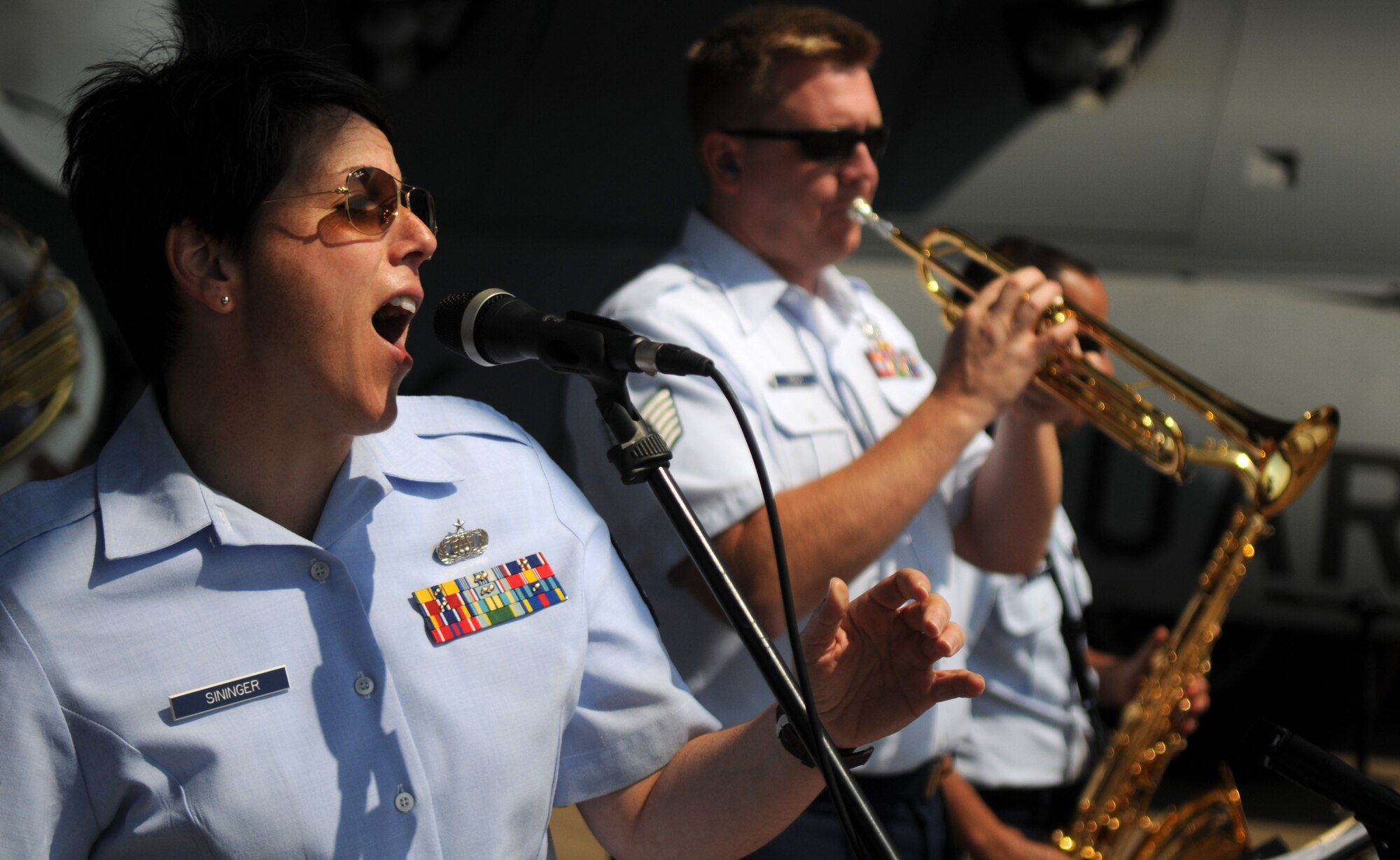 Tech. Sgt. Saundra Sininger, trombonist and vocalist, and the United States Air Forces in Europe jazz band, Wings of Dixie, perform beneath the wing of a New York Air National Guard C-17 Globemaster III at Africa's largest air show Sept. 20, 2014. A total force team of U.S. Air Force Airmen and U.S. Army Soldiers attended the Africa Aerospace & Defence Expo 2014 at Waterkloof Air Force Base, South Africa, to showcase the United States' commitment to its partnership with South Africa. (U.S. Air Force photo by Tech. Sgt. Austin M. May/Released)