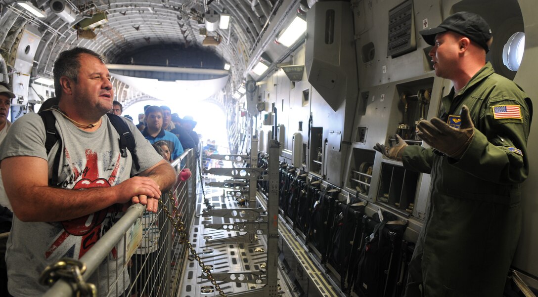 Staff Sgt. Christopher Cumming, C-17 Globemaster III loadmaster, explains cargo flight operations to guests at Africa's largest air show Sept. 20, 2014. Cumming and a total force team of U.S. Air Force Airmen and U.S. Army Soldiers attended the Africa Aerospace & Defence Expo 2014 at Waterkloof Air Force Base, South Africa, to showcase the United States' commitment to its partnership with South Africa. (U.S. Air Force photo by Tech. Sgt. Austin M. May/Released)