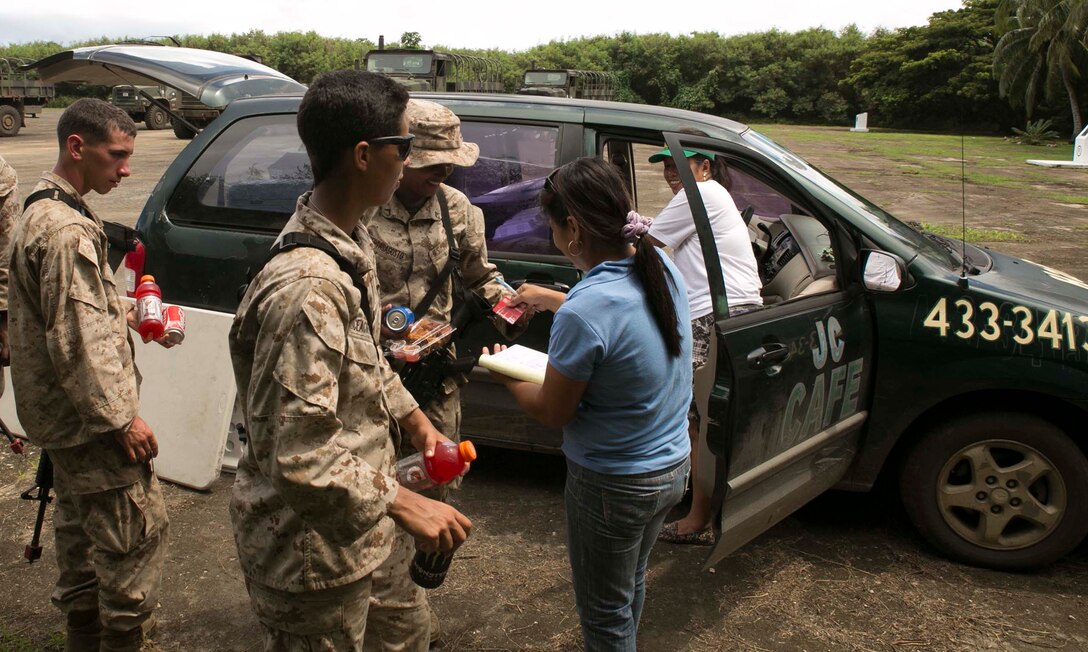 U.S. Marines purchase food and drinks from a local vendor Sept. 20 during exercise Valiant Shield 2014 at a compound near Tinian’s North Field, Commonwealth of the Northern Mariana Islands. “It really boosts our sales,” said Lot Bunao, manager of J.C. Café on Tinian. “It’s really a chain reaction and boosts our entire economy. For example, the food we sell to them is made from stuff we buy locally at the stores here.” The Marines are with 1st Battalion, 3rd Marine Regiment, currently assigned to 3rd Marine Division, III Marine Expeditionary Force. (U.S. Marine Corps photo by Lance Cpl. Tyler Ngiraswei)