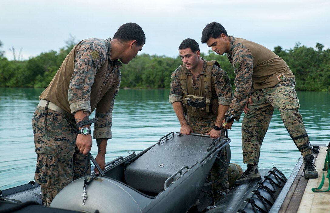 Marines load a diver propulsion device into a combat rubber raiding craft Sept. 20 at U.S. Naval Base Guam during Exercise Valiant Shield 2014. The DPDs will aid the Marines conduct night infiltration, in which Marines will quietly come ashore once night falls. Valiant Shield is a U.S.-only exercise integrating Navy, Air Force, Army, and Marine Corps assets, offering real-world joint operational experience to develop capabilities that provide a full range of options to defend U.S. interests and those of its allies and partners.  The Marines are reconnaissance men with 3rd Reconnaissance Battalion, 3rd Marine Division, III Marine Expeditionary Force. (U.S. Marine Corps photo by Cpl. Lena Wakayama/Released)