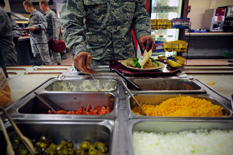Wolf Pack Airmen walk down the food line at the dining facility during lunch hours at Kunsan Air Base, Republic of Korea, July 10, 2014. The dining facility serves Wolf Pack members for breakfast, lunch, dinner, and even a midnight meal. (U.S. Air Force photo by Senior Airman Taylor Curry/Released) 