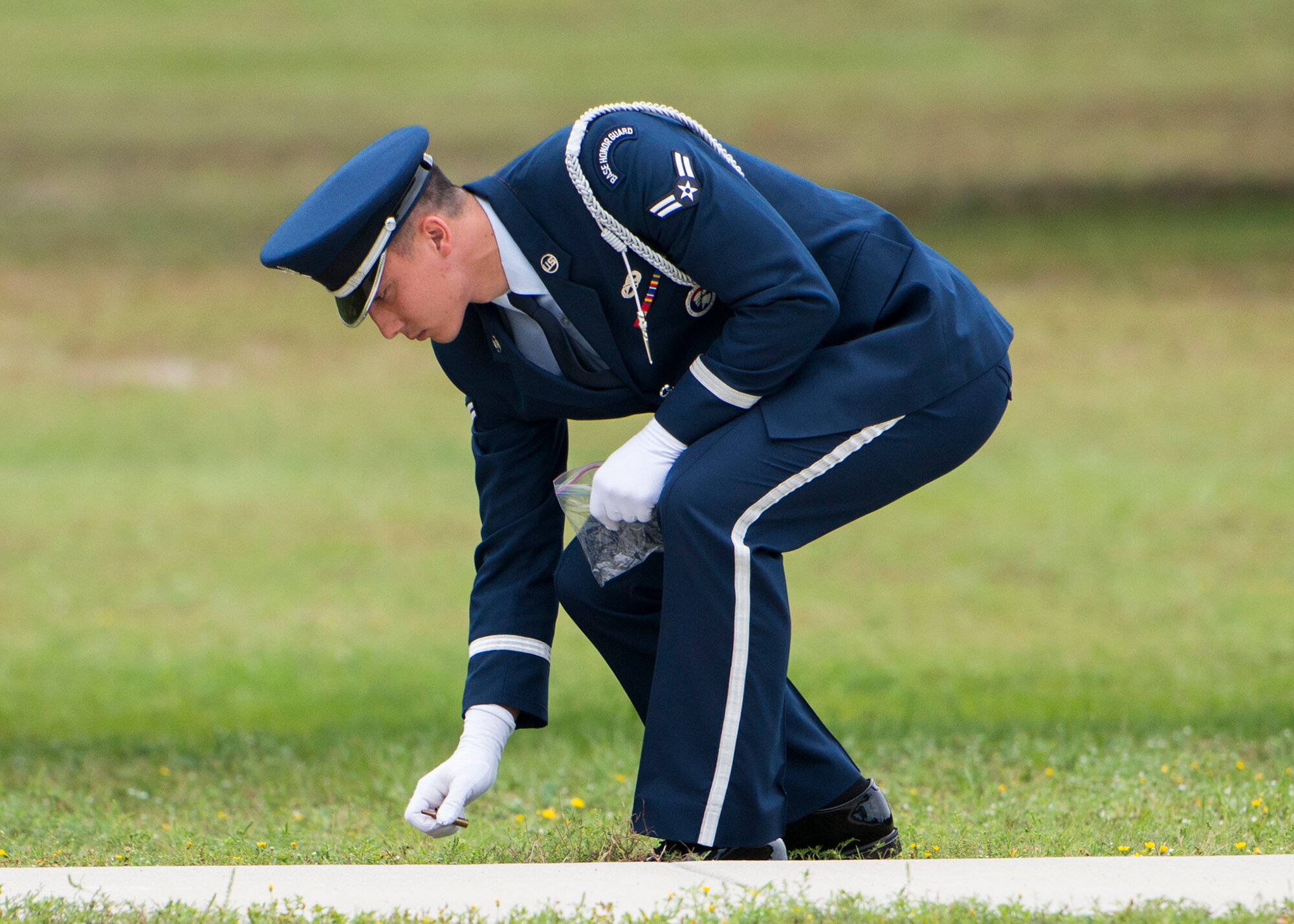 A member of Team Eglin Honor Guard picks up shells after the rifle volley team closed the base's POW/MIA remembrance ceremony Sept. 19 at the Air Force Armament Museum. The ceremony paid tribute to those military members who have yet to return home from defending America. The event featured tributes, guest speakers and honor guard procedures. (U.S. Air Force photo/Tech. Sgt. Jasmin Taylor)