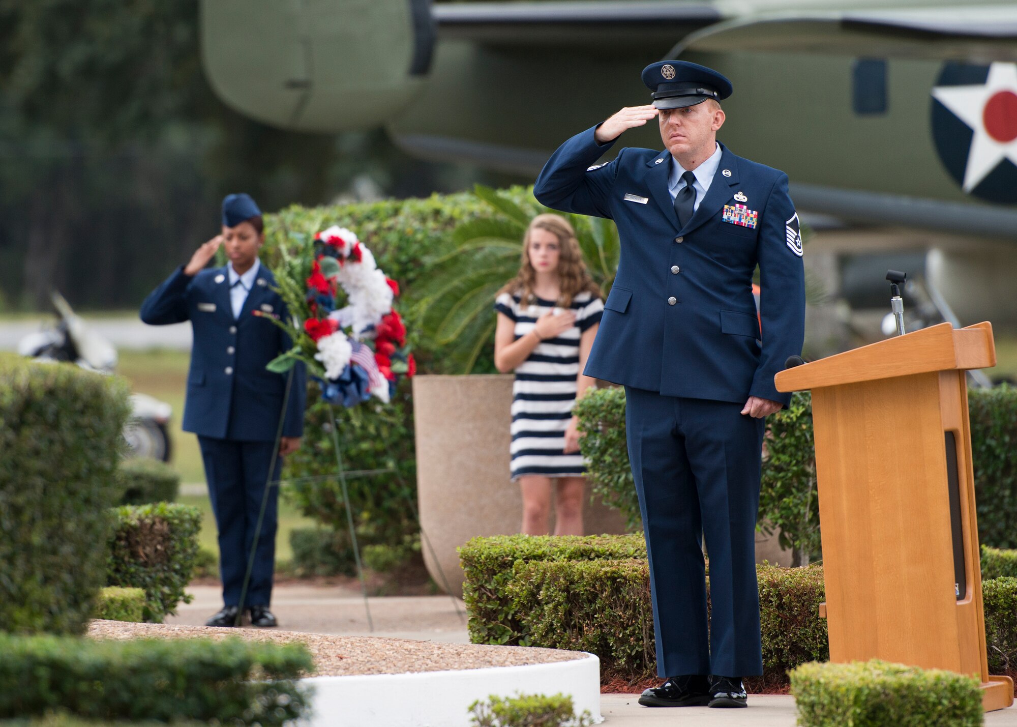Master Sgt. Ted Hackler, narrator of the event, salutes during Taps at Eglin's POW/MIA remembrance ceremony Sept. 19 at the Air Force Armament Museum. The ceremony paid tribute to those military members who have yet to return home from defending America. The event featured tributes, guest speakers and honor guard procedures. (U.S. Air Force photo/Tech. Sgt. Jasmin Taylor)