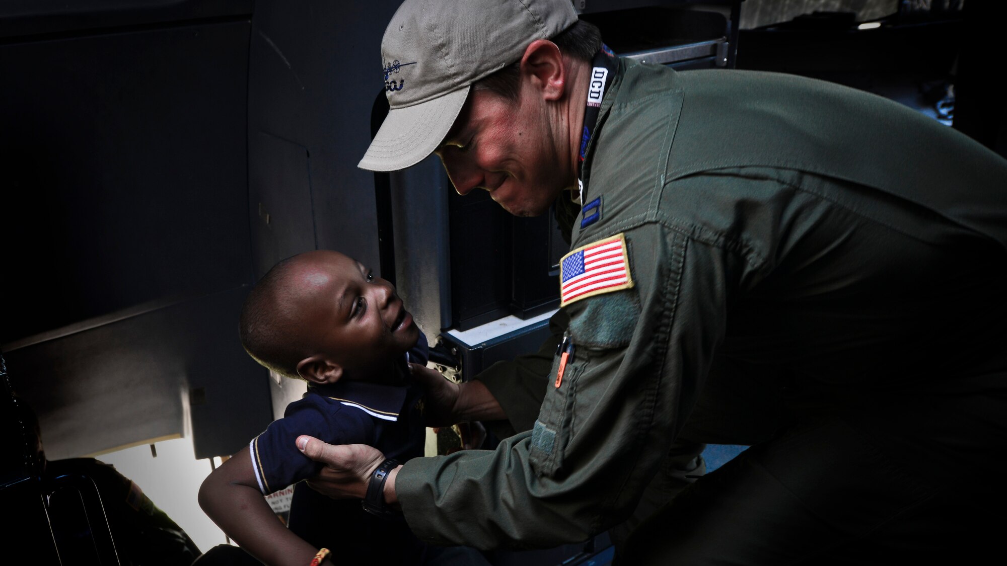 Captain Lindsey Kinsinger, 37th Airlift Squadron pilot, helps a child into the flight deck of a C-130J Super Hercules at the Africa Aerospace & Defence Expo at Waterkloof Air Force Base, South Africa, Sept. 20, 2014.  The C-130 was part of a total-force team of Guard, Reserve and active-duty Soldiers and Airmen at the expo. Air show attendees were given an opportunity to view the inside of an Air Force C-130J and C-17 Globemaster III. (U.S. Air Force photo/Staff Sgt. Travis Edwards)