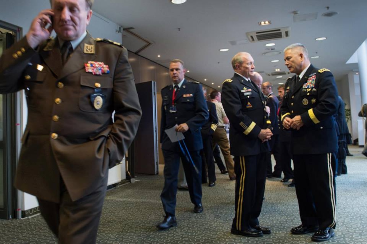Army Gen. Martin E. Dempsey, chairman of the Joint Chiefs of Staff, center, talks with Army Gen. John Campbell, commander of the International Security Assistance Force in Afghanistan, right, between sessions of the NATO Military Committee conference in Vilnius, Lithuania, held Sept. 20-21, 2014. DoD photo by D. Myles Cullen
