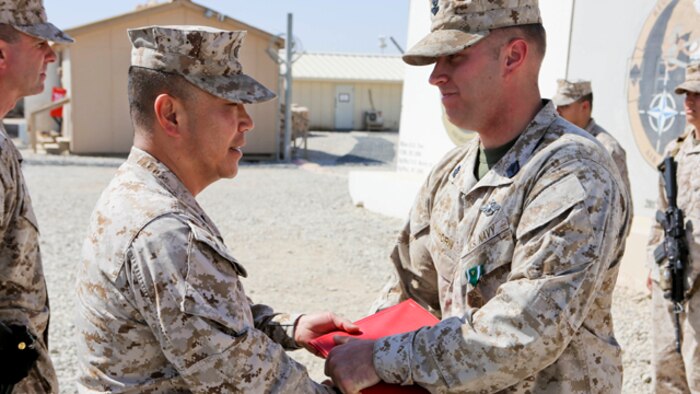 Brigadier Gen. Daniel D. Yoo, left, commander, Regional Command and Marine Expeditionary Brigade – Afghanistan, awards Petty Officer 2nd Class Joshua Van Horn, a corpsman with 1st Air Naval Gunfire Liaison Company, a Navy and Marine Corps Commendation Medal with Combat Distinguishing Device during an award ceremony aboard Camp Leatherneck, Afghanistan, Sept. 17, 2014. Van Horn received the award for heroic achievement while being a first responder to Marine casualties after their vehicle struck an improvised explosive device.