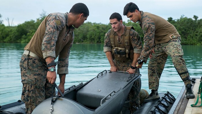 Marines load a diver propulsion device into a combat rubber raiding craft Sept. 20 at U.S. Naval Base Guam during Exercise Valiant Shield 2014. The device aids the Marines conducting night infiltration. Valiant Shield is a U.S.-only exercise integrating Navy, Air Force, Army, and Marine Corps assets, offering real-world joint operational experience to develop capabilities, which provide a full range of options to defend U.S. interests and those of its allies and partners.  The Marines are reconnaissance men with 3rd Reconnaissance Battalion, 3rd Marine Division, III Marine Expeditionary Force. 