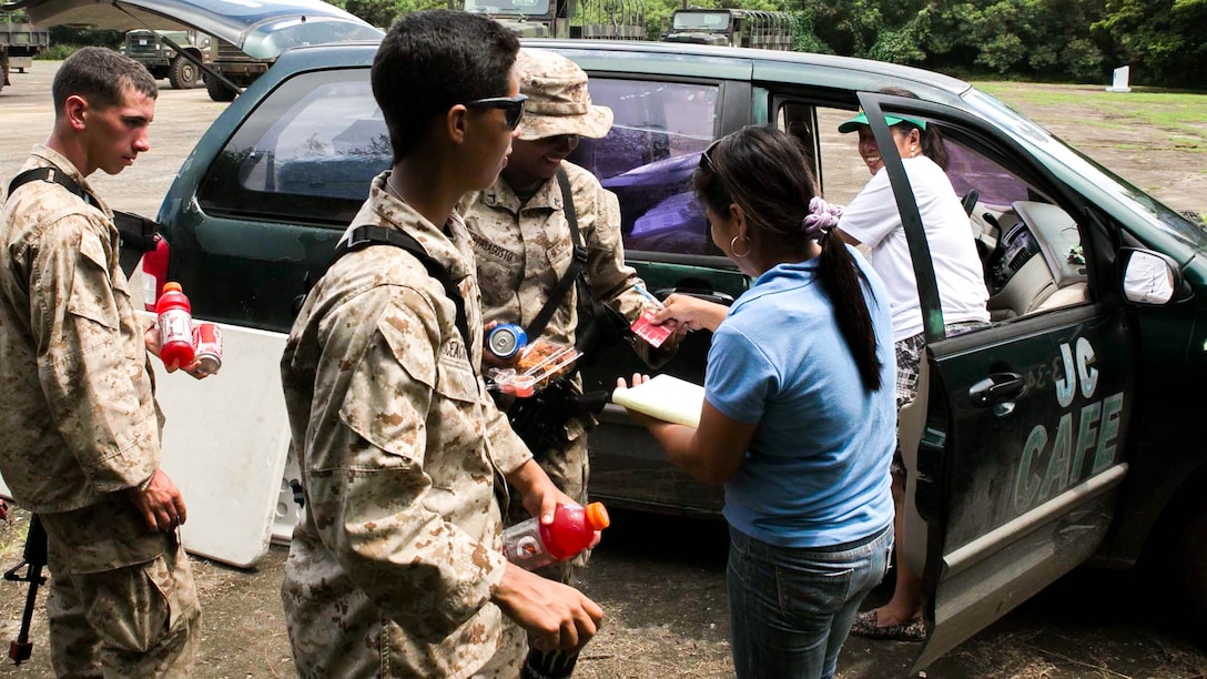 Marines purchase food and drinks from a local vendor Sept. 20 during Exercise Valiant Shield 2014 at a compound near Tinian’s North Field, Commonwealth of the Northern Mariana Islands. The Marines are with 1st Battalion, 3rd Marine Regiment, currently assigned to 3rd Marine Division, III Marine Expeditionary Force. (U.S. Marine Corps photo by Lance Cpl. Tyler Ngiraswei)