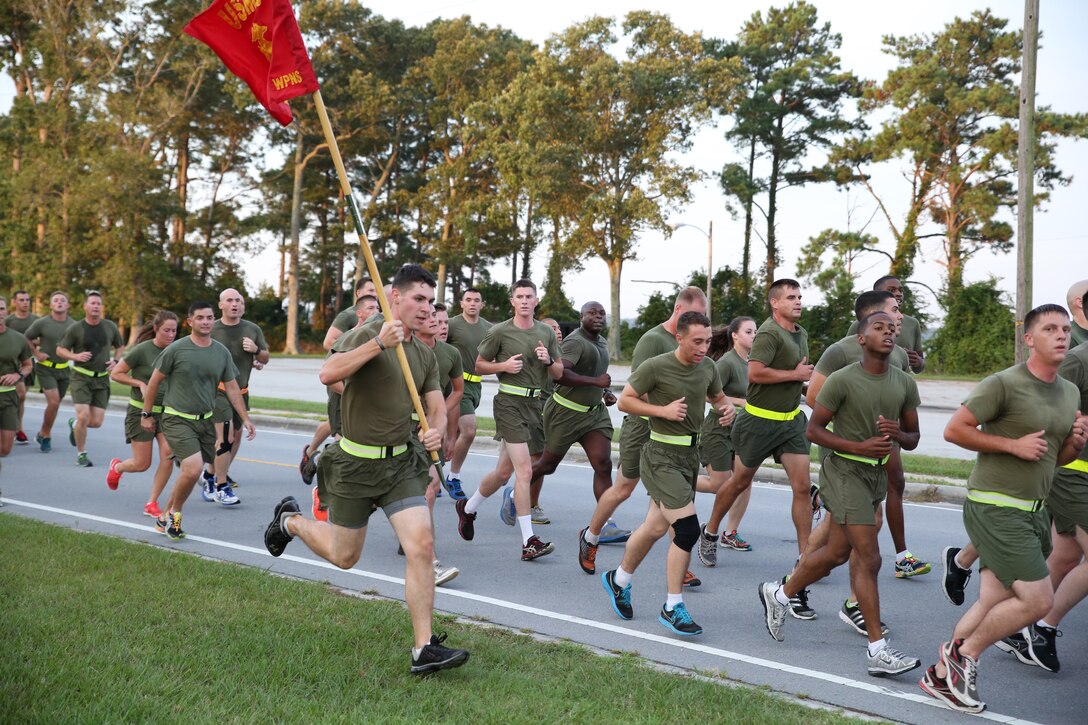 Marines and sailors with the Ground Combat Element Integrated Task Force run aboard Marine Corps Base Camp Lejeune, North Carolina, Sept. 19, 2014. The task force ran three miles, calling cadence and showcasing guidons along the way. The run was in celebration of the uncasing of the units organizational colors. From October 2014 to July 2015, the Ground Combat Element Integrated Task Force will conduct individual and collective skills training in designated combat arms occupational specialties in order to facilitate the standards based assessment of the physical performance of Marines in a simulated operating environment performing specific ground combat arms tasks. (U.S. Marine Corps photo by Cpl. Paul S. Martinez/Released)