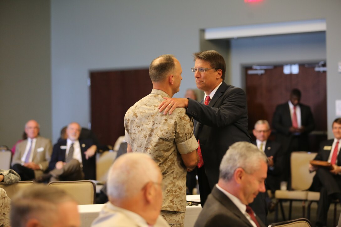 Col. Chris Pappas III, left, shakes hands with Governor Pat McCrory during a meeting at Miller’s Landing at Marine Corps Air Station Cherry Point, N.C., Sept. 16, 2014. Pappas is the air station commanding officer and McCrory is the governor of North Carolina.