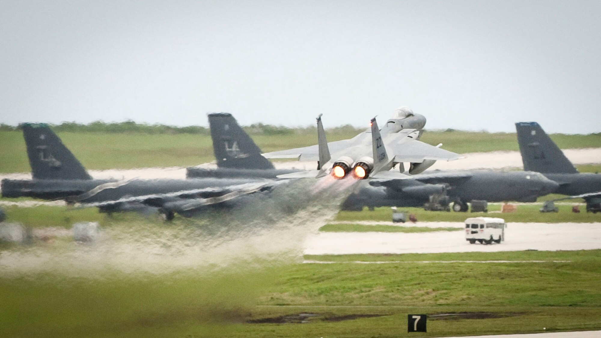 A U.S. Air Force F-15C Eagle takes off in front of B-52 Stratofortesses during Valiant Shield 2014, Andersen Air Force Base, Guam, Sept. 16, 2014. Valiant Shield is a U.S.-only exercise, integrating U.S. Navy, Air Force, U.S. Army and U.S. Marine Corps assets, offering real-world joint operational experience to develop capabilities that provide a full range of options to defend U.S. interests and those of its allies and partners.  (U.S. Air Force Photo by Staff Sgt. William Banton/Released)