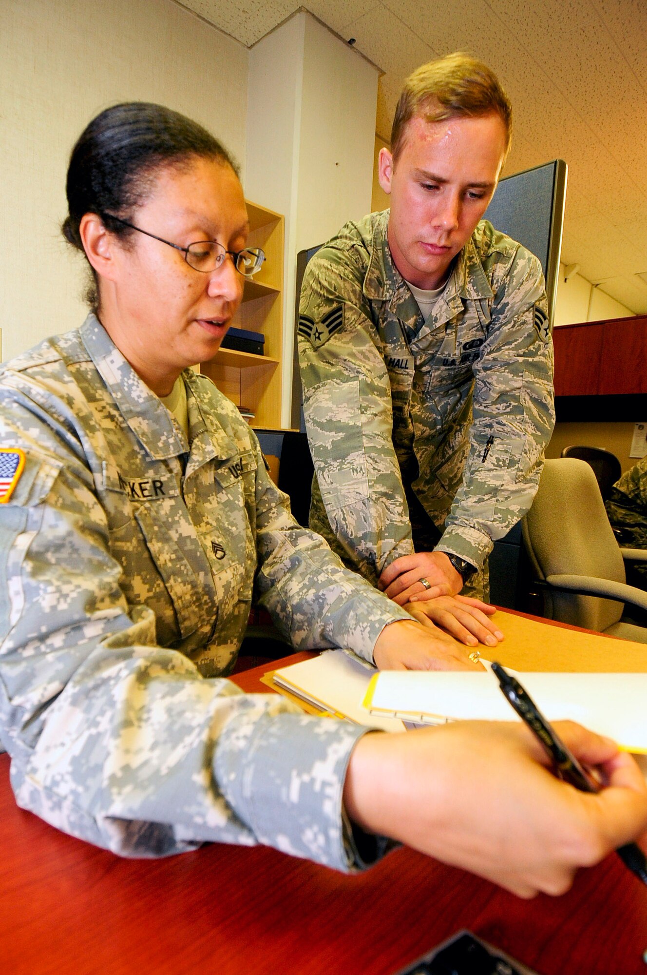 U.S. Army Staff Sgt. Ines Necker, 18th Contracting Squadron contract specialist, reviews a contract with Senior Airman Cameron Doncet Hall, 18th Contracting Squadron contract specialist, during the soft close-out at Kadena Air Base, Japan, Sept. 19, 2014. During soft close-out, squadrons make sure that all funds are obligated and make plans in case they receive additional money. Both members are part of "B Flight" who buys commodities and services for the 18th Mission Support Group and 18th Civil Engineer Group. (U.S. Air Force Photo by Staff Sgt. Darnell T. Cannady/Released) 