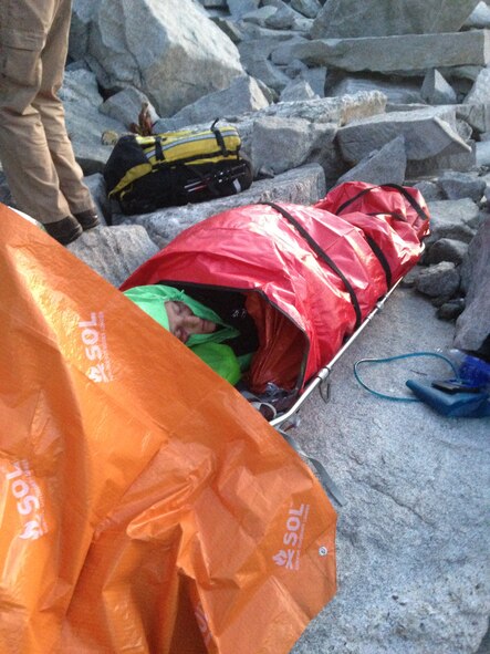 Ammi Midstokke is secured to a Stokes litter prior to being hoisted onto a UH-1N Iroquois helicopter from the 36th Rescue Flight following an accident near Priest Lake, Idaho, Sept. 20, 2014. Midstokke suffered a fracture to her foot and because of harsh terrain and lack of daylight, she was trapped overnight with a Priest Lake Search and Rescue crew. (Courtesy photo by Jason Luthy)