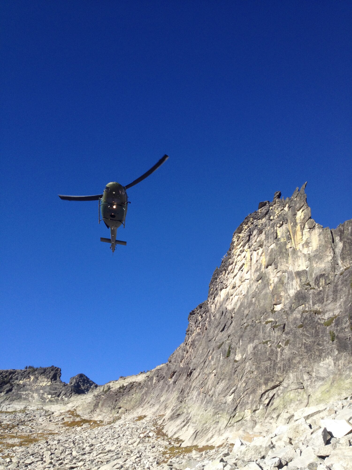 Fairchild Air Force Base crewmembers from 'Rescue 13' approach the scene of a rescue mission in their UH-1N Iroquois helicopter near Priest Lake, Idaho, Sept. 20, 2014. A 36-year-old female was entrapped by a 1.5 ton boulder while hiking in the area. The four-man crew extradited the victim out of the area after a ground crew managed to free her from the boulder. (Courtesy photo by Jason Luthy)