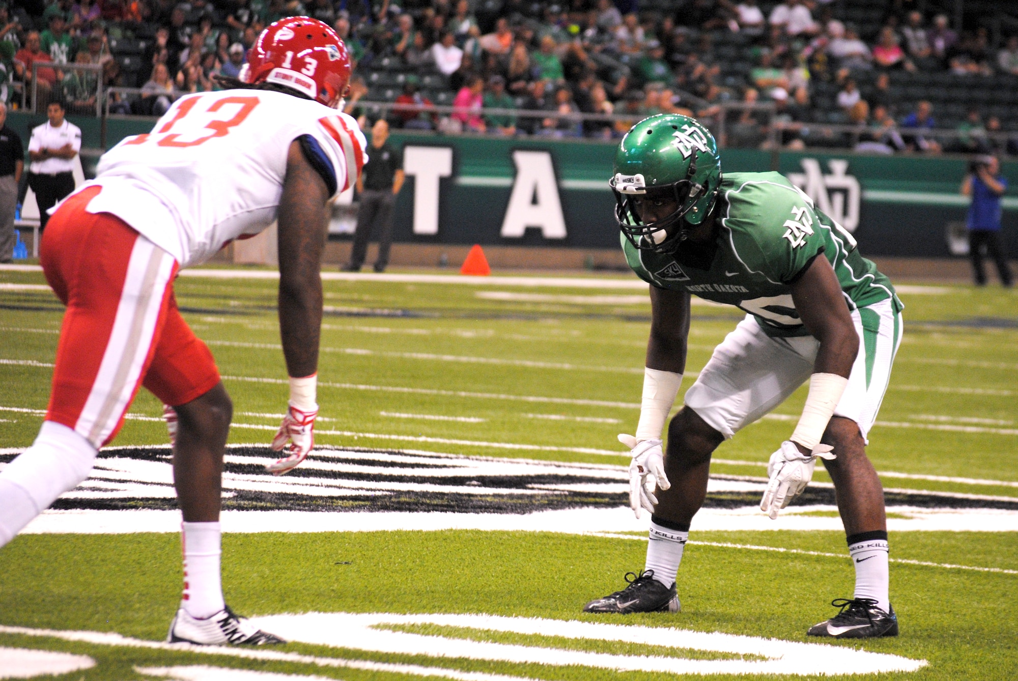 University of North Dakota cornerback Alex Tillman lines up in tight man coverage against Stony Brook University wide receiver Jahrie Level during the fourth quarter of the Military Appreciation Day college football game, Sept. 20, 2014, at the Alerus Center in Grand Forks, N.D. Tillman scored the only defensive touchdown in the game. The 92-yard-long defensive play for six points is the longest interception return for a touchdown in UND history since 1998.  The UND defeated the Stony Brook University Seawolves 13 to 3. UND has been providing military families with free tickets to one of their home college football game for more than a dozen years.  (U.S. Air Force photo/Staff Sgt. Luis Loza Gutierrez)
