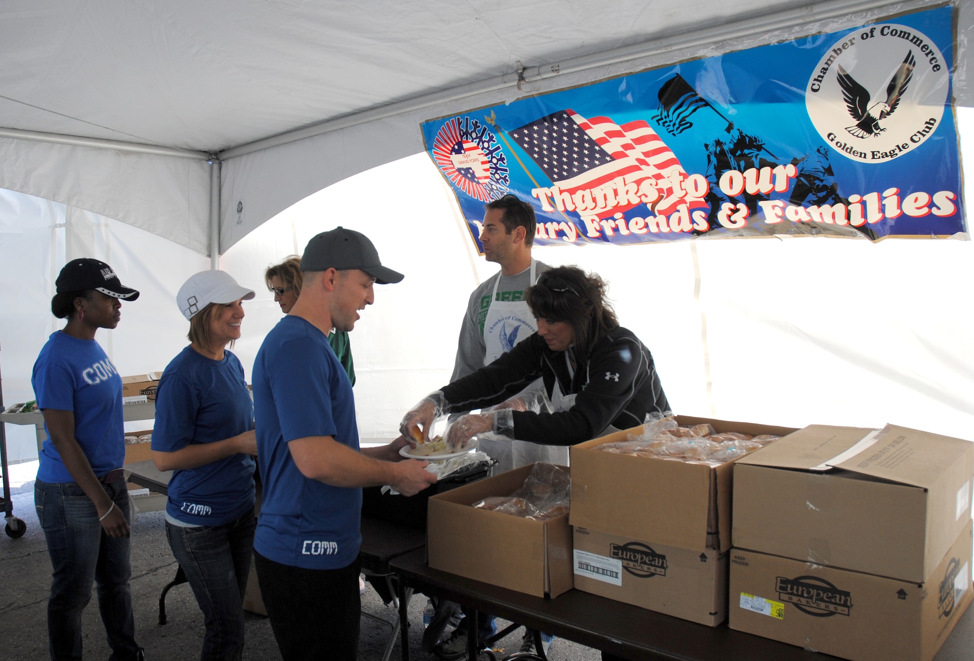 Members from the Grand Forks Military Affairs Committee and Chamber of Commerce Golden Eagles Club serve three members of from the 319th Communication Squadron from Grand Forks Air Force Base, N.D., during the 17th Annual Maury Rothkopf Military Appreciation Day tailgate party held Sept. 20, 2014, at the Alerus Center Tailgate Village in Grand Forks, N.D. Military members and their families were treated to a free meal and free tickets to the a college football game as part of Military Appreciation Day sponsored by the University of North Dakota and the Grand Forks and East Grand Forks, Minn., Chambers of Commerce. (U.S. Air Force photo/Staff Sgt. Luis Loza Gutierrez)
