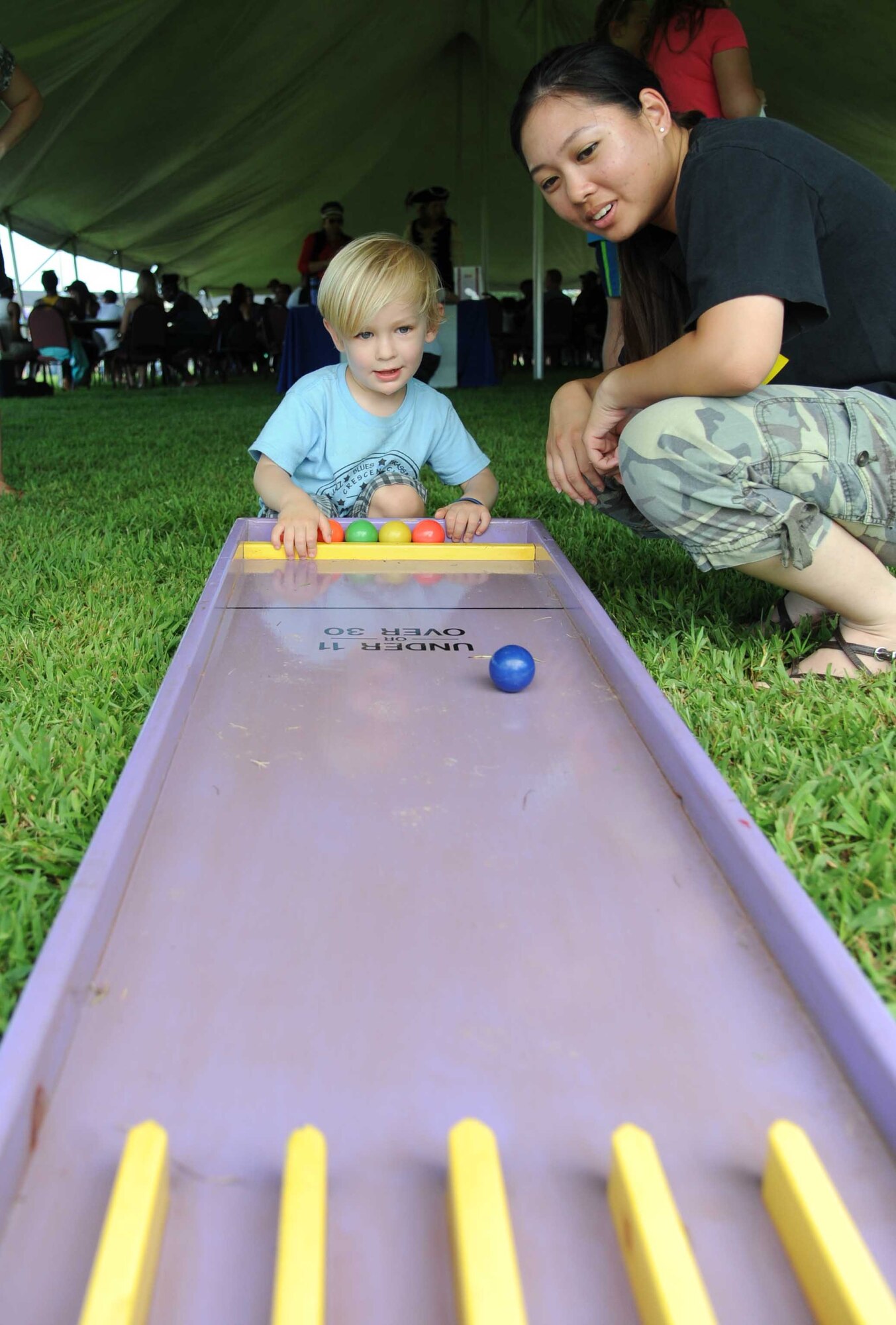 The son of Tech. Sgt. Phillip Harris, 336th Training Squadron, and Airman Basic Crystal Ngo, 338th Training Squadron, play ski ball together during the Air Force’s 67th birthday celebration Sept. 19, 2014, Keesler Air Force Base, Miss. The event also included a cake cutting ceremony, music, games, contests and food.  (U.S. Air Force photo by Kemberly Groue)