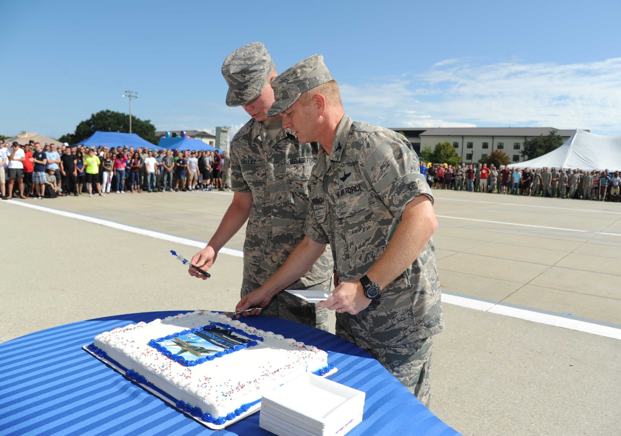 Airman Basic Anthony Salley, 338th Training Squadron and the youngest Airman at Keesler, assists Col. Dennis Scarborough, 81st Training Wing vice commander, with cutting the birthday cake during the Air Force’s 67th birthday celebration Sept. 19, 2014, Keesler Air Force Base, Miss. The event also included music, games, contests and food.  (U.S. Air Force photo by Kemberly Groue)
