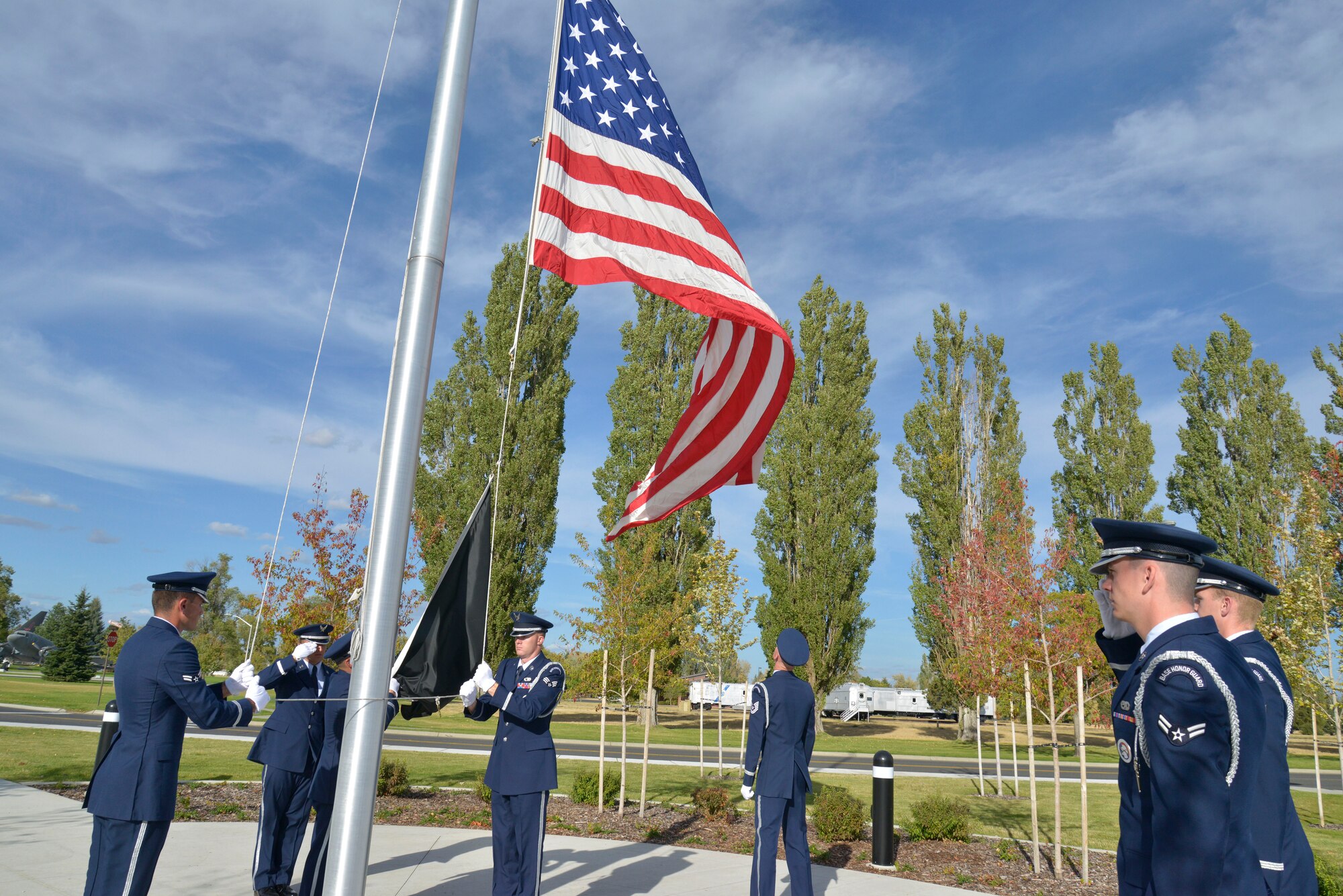 Members of the Team Fairchild Honor Guard perform a ceremonial retreat during a ceremony honoring prisoners of war and those missing in action at Fairchild Air Force Base, Washington, Sept. 19, 2014. Team Fairchild gathered in front of the wing headquarters building to pause in remembrance of the sacrifices and service of those who were prisoners of war as well as those who are missing in action. (U.S. Air Force photo by Airman 1st Class Janelle Patiño/Released)