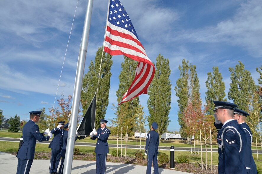 Members of the Team Fairchild Honor Guard perform a ceremonial retreat during a ceremony honoring prisoners of war and those missing in action at Fairchild Air Force Base, Washington, Sept. 19, 2014. Team Fairchild gathered in front of the wing headquarters building to pause in remembrance of the sacrifices and service of those who were prisoners of war as well as those who are missing in action. (U.S. Air Force photo by Airman 1st Class Janelle Patiño/Released)