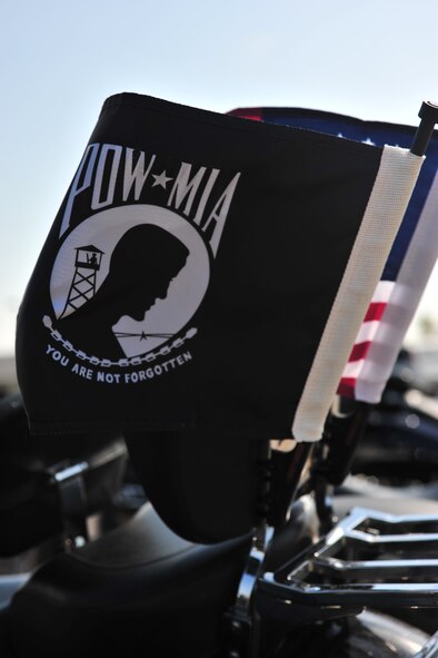 The Prisoner of War and Missing in Action Flag, and the U.S. Flag sit atop a motorcycle on Minot Air Force Base, N.D., Sept. 19, 2014. The motorcycle riders honored the POWs and MIAs by leading a three hour motorcycle run in their memory. (U.S. Air Force photo/Senior Airman Malia Jenkins)