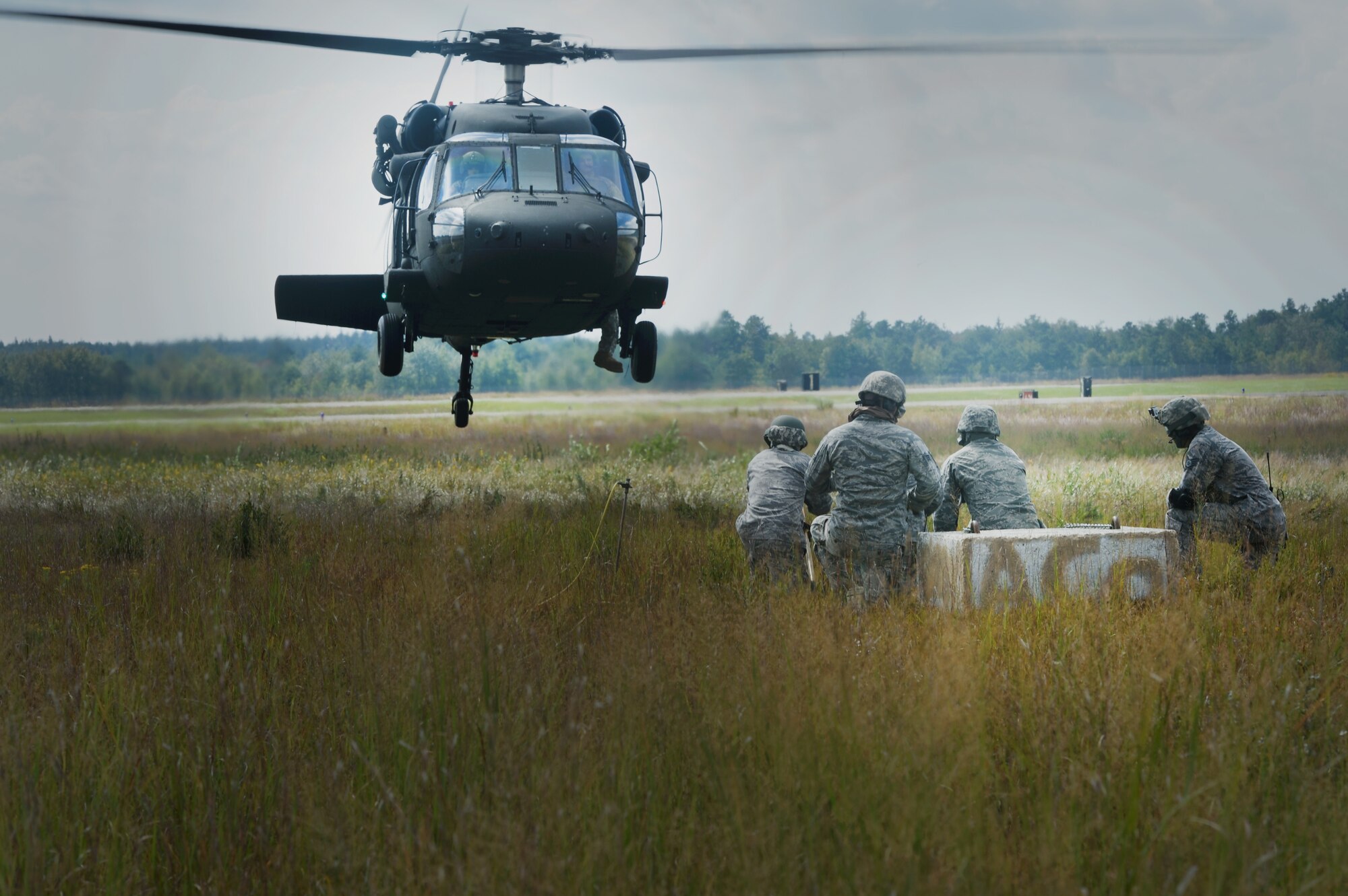 JOINT BASE MCGUIRE-DIX-LAKEHURST, N.J. -- Members of the 621 Contingency Response Wing wait for a U.S. Army UH-60 Black Hawk to get closer to attach simulated cargo during the revamped sling-load training here, Sept. 16, 2014. The new sling-load training is scheduled to be conducted quarterly. (U.S. Air Force photo by Staff Sgt. Gustavo Gonzalez)
