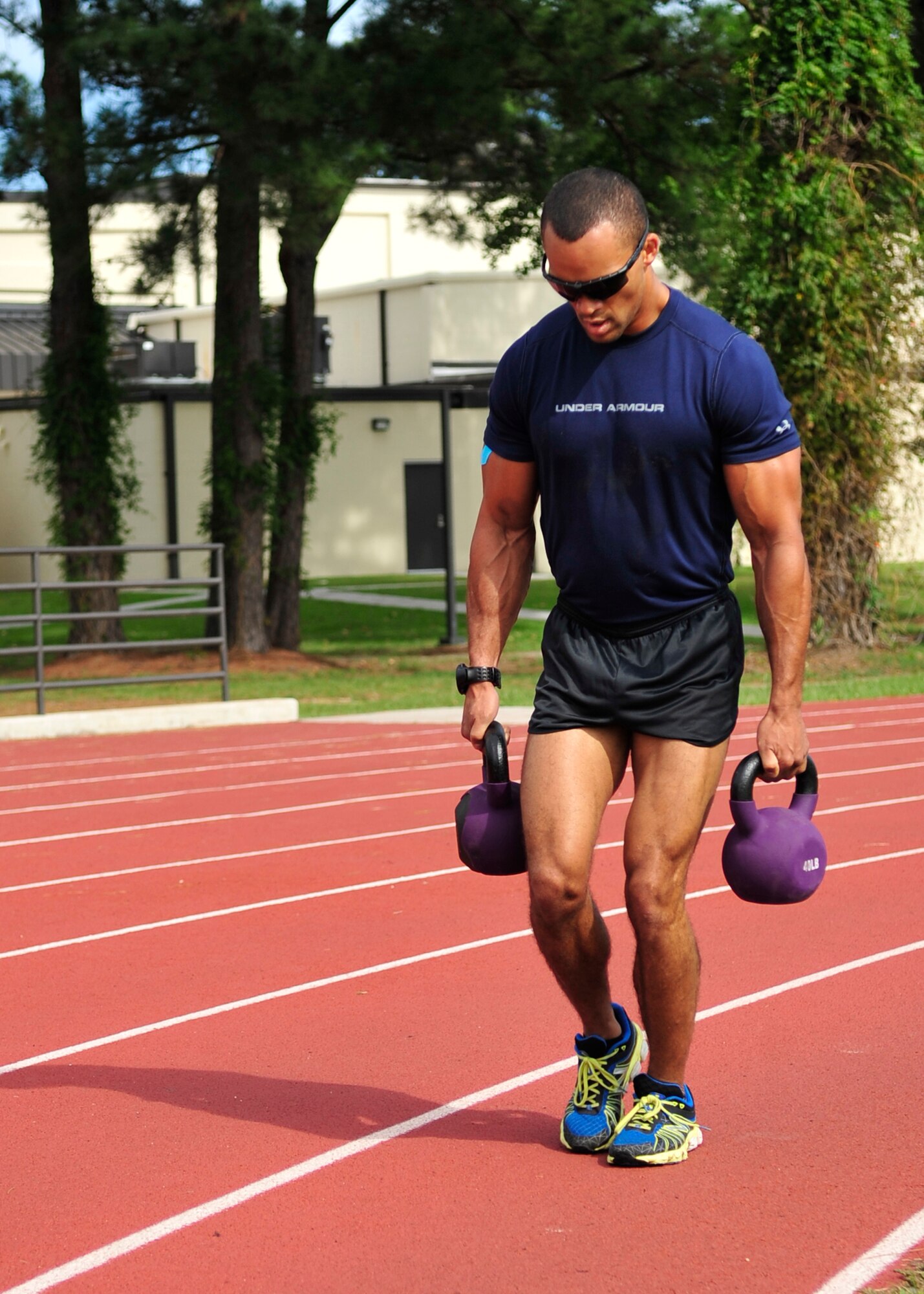 Staff Sgt. Jordan Hansen-Lewis, 4th Aircraft Maintenance Squadron avionics specialist, carries kettle bells around the track during the 2014 Combat Fitness Challenge at Seymour Johnson Air Force Base, North Carolina, Sept. 20, 2014. The Combat Fitness Challenge is an advanced circuit-style fitness course focusing on strength and cardiovascular fitness. (U.S. Air Force photo/Airman 1st Class Shawna L. Keyes)
