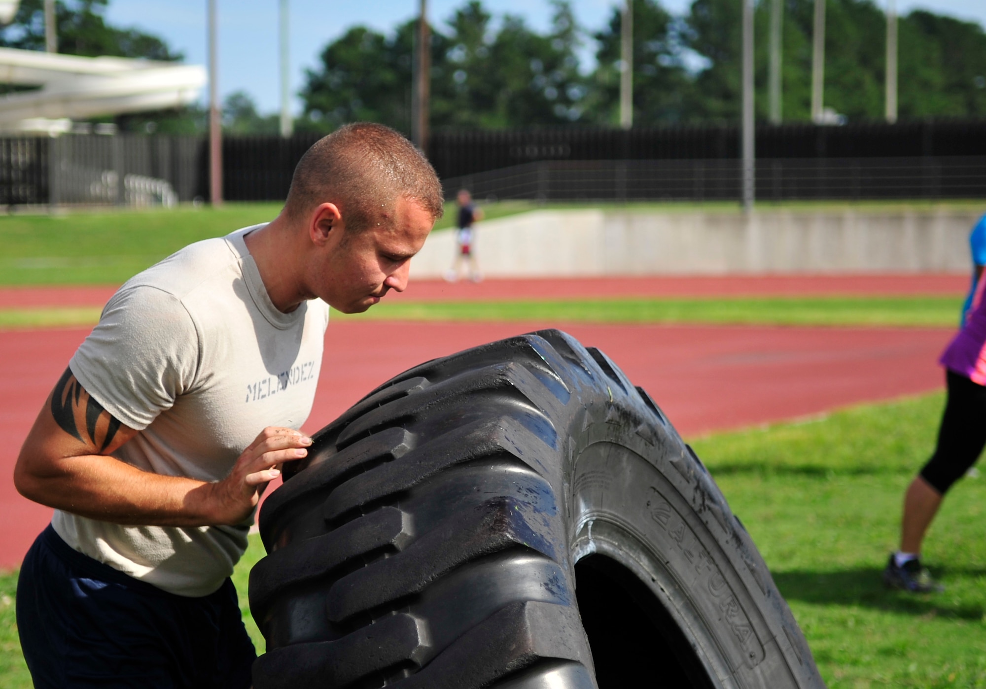 Senior Airman Jordan Melendez, 4th Aircraft Maintenance Squadron avionics specialist, flips a tire during the 2014 Combat Fitness Challenge at Seymour Johnson Air Force Base, North Carolina, Sept. 20, 2014. The Combat Fitness Challenge is an advanced circuit-style fitness course focusing on strength and cardiovascular fitness. (U.S. Air Force photo/Airman 1st Class Shawna L. Keyes)