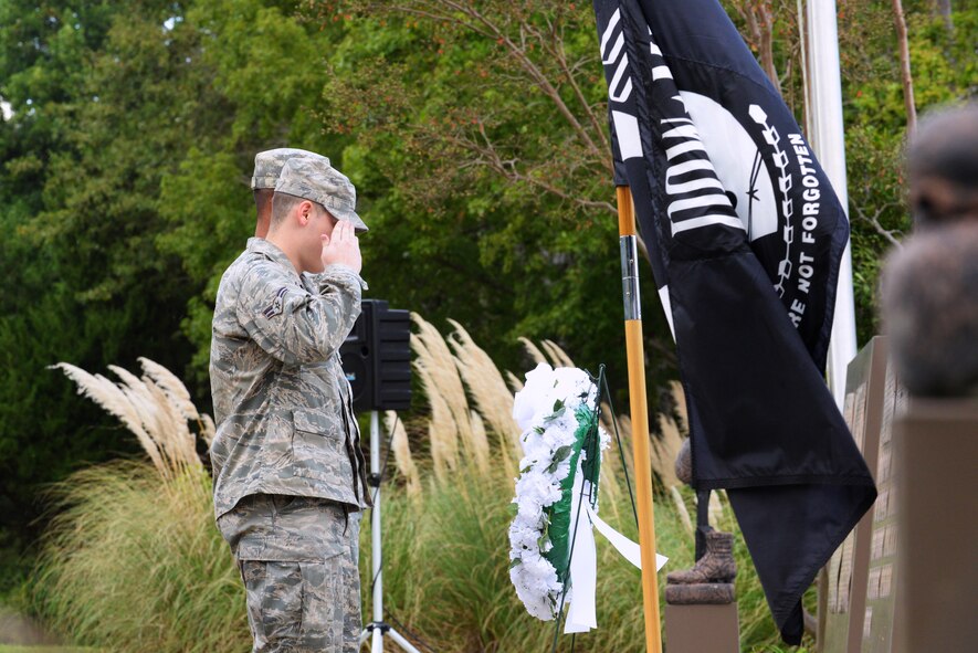 Two U.S. Air Force Airmen salute a wreath laid in remembrance of the prisoners of war and missing in action personnel at Memorial Lake at Shaw Air Force Base, S.C., Sept. 19, 2014. There are more than 83,000 Americans still unaccounted for from previous wars the United States fought in. (U.S. Air Force photo by Airman 1st Class Diana M. Cossaboom/Released)
