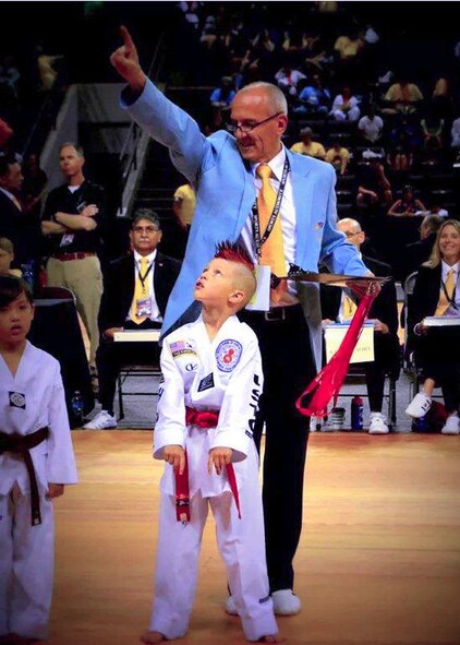 Kelan Wall, 7, son of Master Sgt. Stephen Wall, 43rd Logistics Readiness Squadron, is awarded first place by a judge in the creative forms event at the 6th annual U.S. Open Taekwondo Hanmadang competition in Colorado Springs, Colorado. After months of training, Kelan and his father, Master Sgt. Stephen Wall, 43rd Logistics Readiness Squadron, won gold medals in the three events he competed in, creative and power breaking and traditional forms. Kelan competed in four events and won gold medals in creative breaking and forms, a silver medal in traditional pairs and a bronze medal in traditional forms. There were a total of 1,600 competitors from 26 states and South Korea in this year’s two-day competition. (Courtesy photo/Melissa Wall)