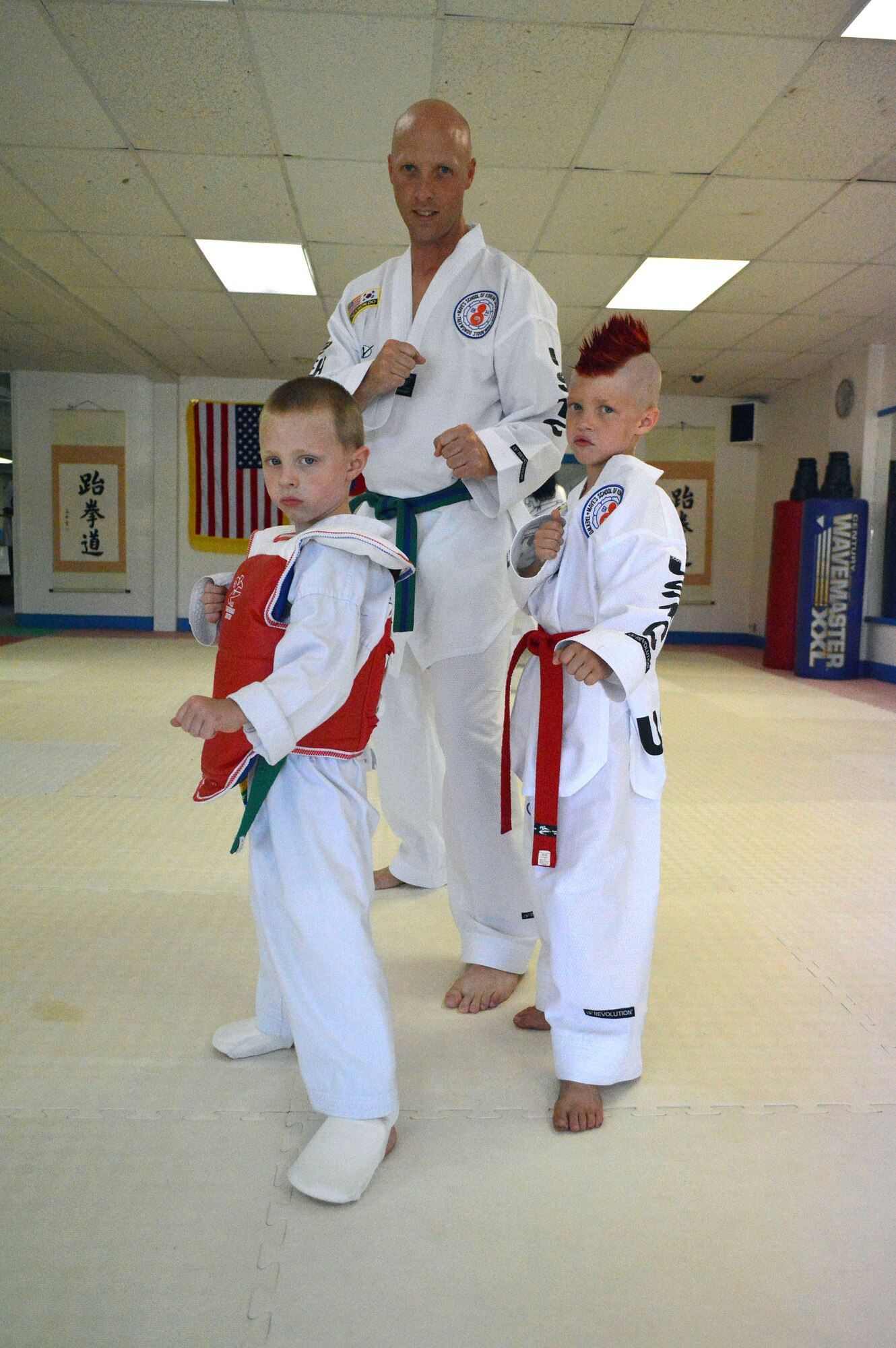 Master Sgt. Stephen Wall, 43rd Logistics Readiness Squadron, poses with his sons Mason, 5, left, and Kelan, 7, at the U.S. Taekwondo Center in Spring Lake, North Carolina before attending the 6th annual U.S. Open Taekwondo Hanmadang competition in Colorado Springs, Colorado. Wall won gold medals in the three events he competed in, creative and power breaking and traditional forms. Kelan competed in four events and won gold medals in creative breaking and forms, a silver medal in traditional pairs and a bronze medal in traditional forms. There were a total of 1,600 competitors from 26 states and South Korea in this year’s two-day competition. (U.S. Air Force photo/Marvin Krause)